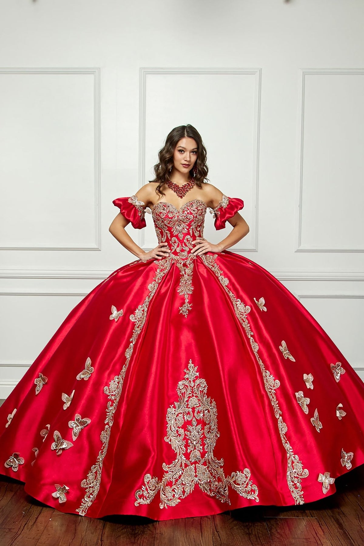Full-length view highlights a red satin quinceañera ball gown with gold embroidery, butterfly applique and full skirt.