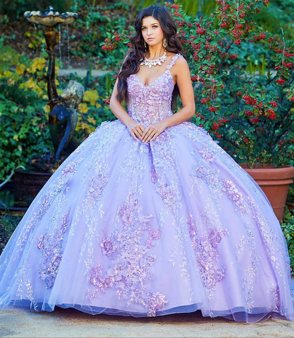 Front view of a woman wearing a lilac quinceañera ball gown with 3D floral applique, rhinestones and sequins