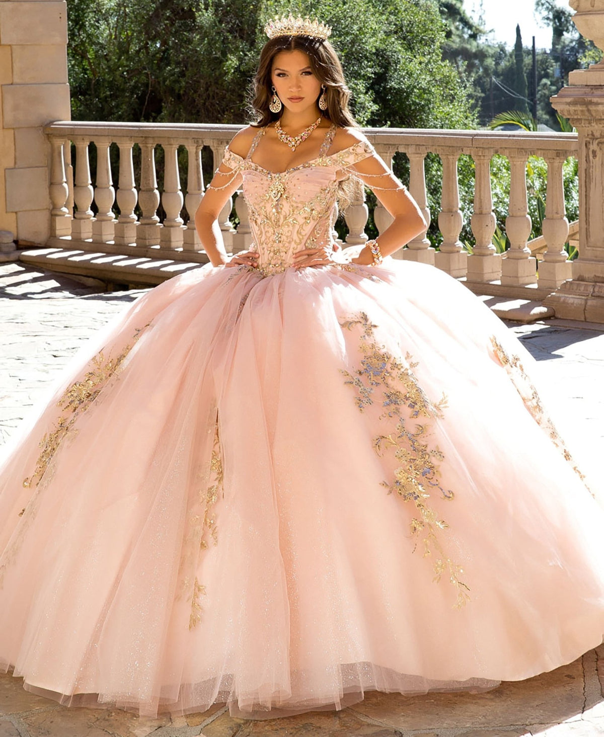 Close-up view reveals a blush quinceañera ball gown with gem-adorned halter strap, detachable bow and corset bodice.