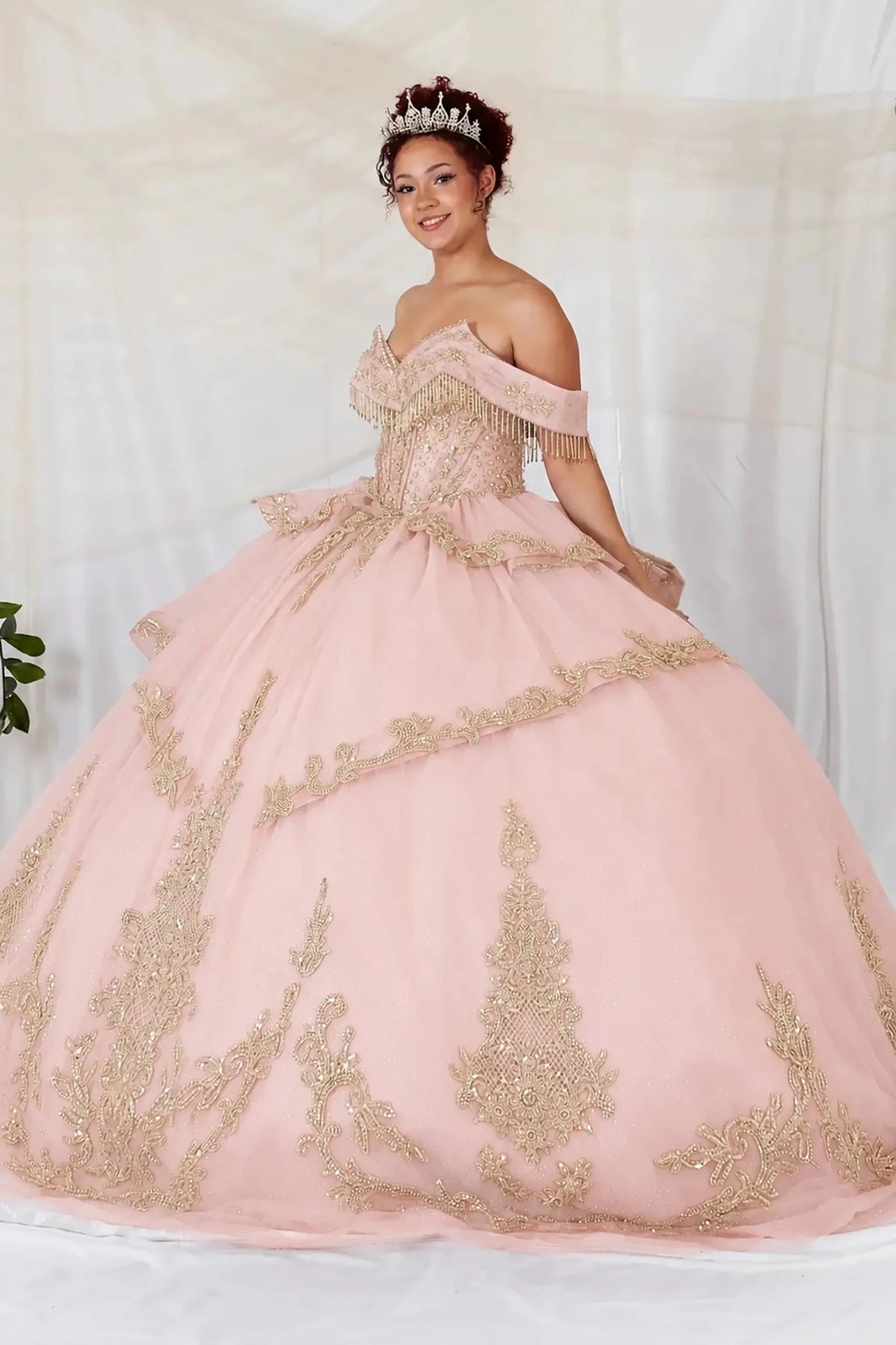 Blush quinceañera ball gown with sweetheart neckline, gold embroidery, beaded fringe bodice and glitter tulle skirt