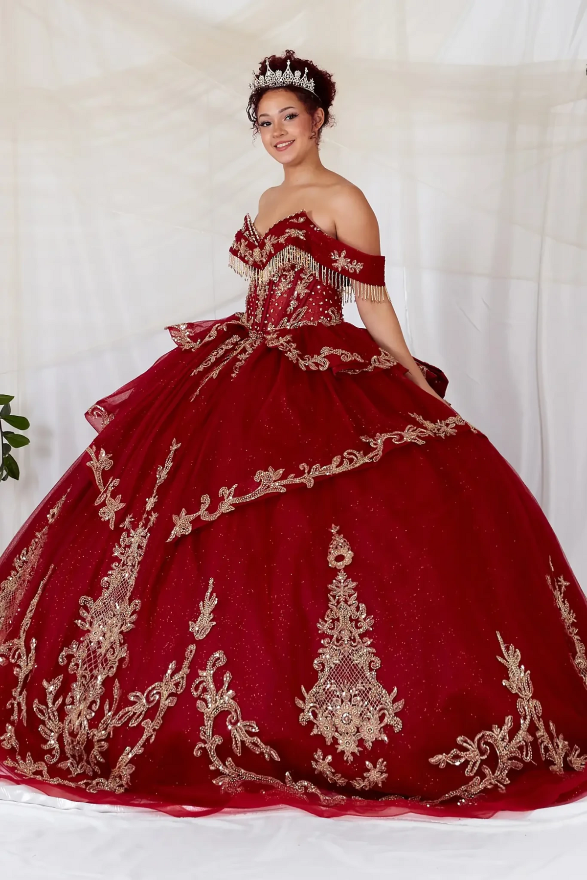 Burgundy quinceañera ball gown with gold embroidery, beaded fringe bodice, off‑shoulder neckline and glitter tulle skirt