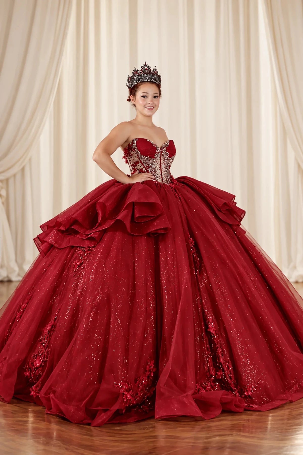 Burgundy quinceañera ball gown shown from an angled front view with tiered ruffles and glitter tulle.