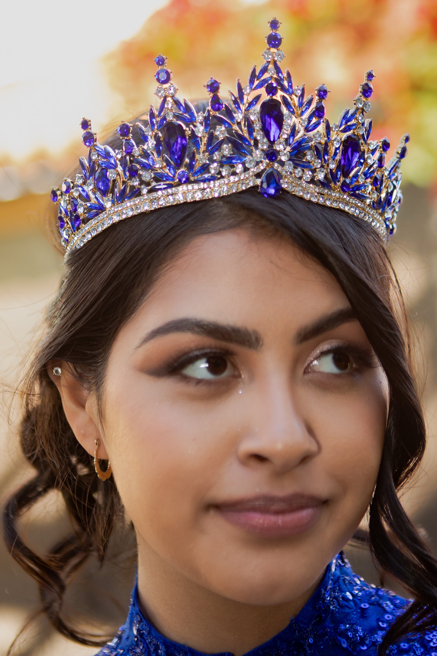 Woman wearing a royal blue tiara with a blurred background