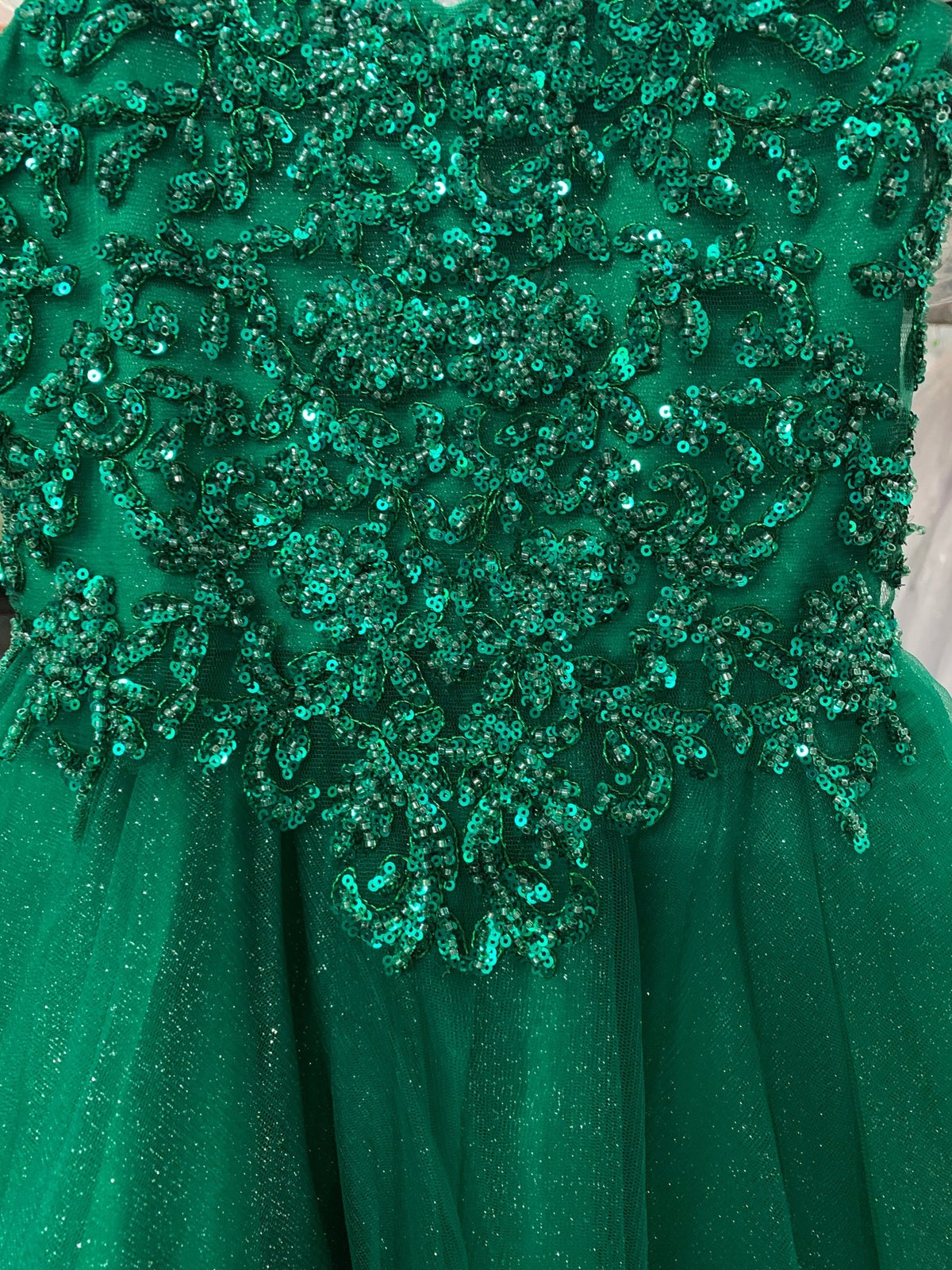 mini quince dress detail of a green kids mini quinceanera dress with layered glitter tulle fabric and detachable long train.