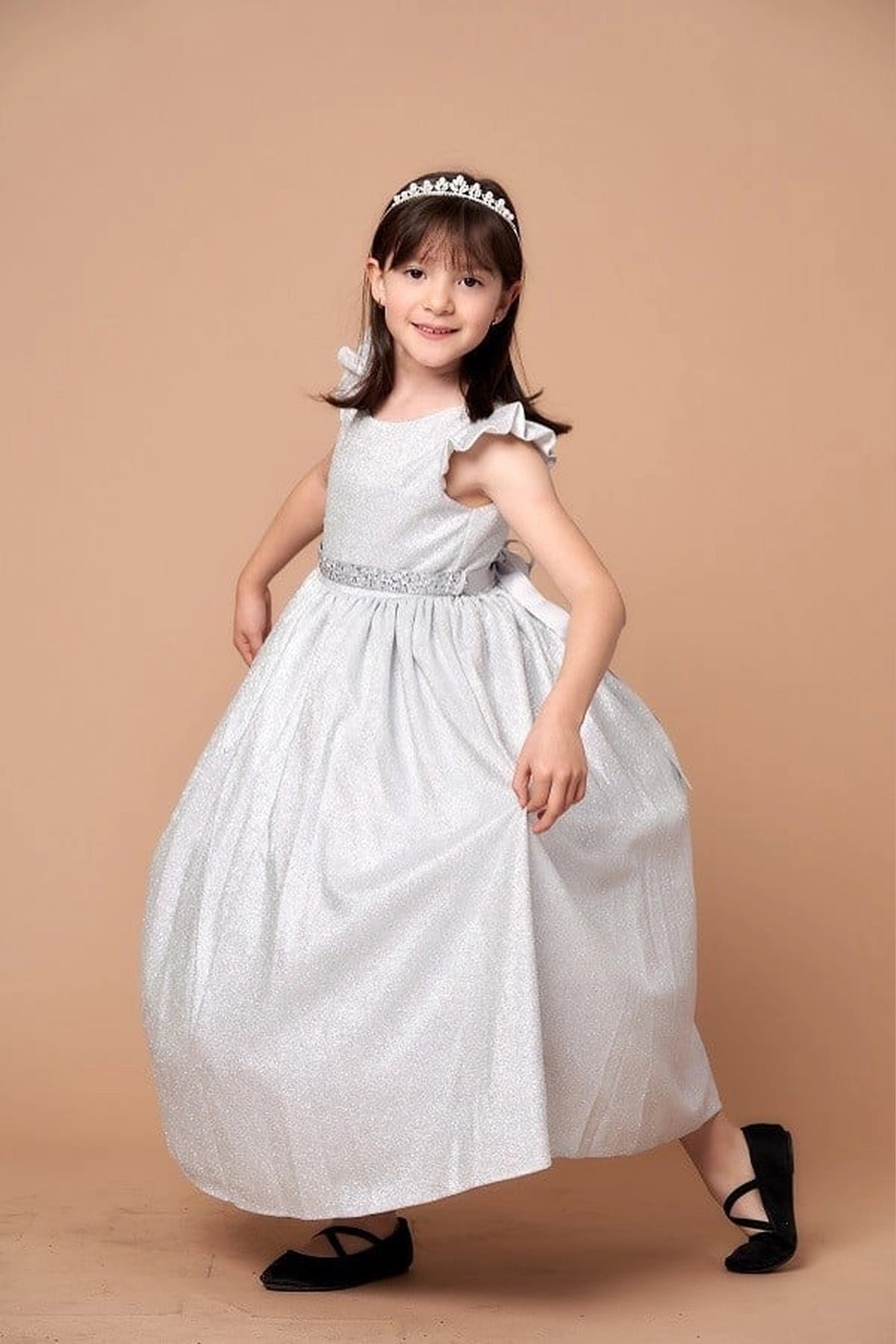 The formal silhouette presents, the Silver mini quince dress showcases metallic full-length party silhouette and ruffle sleeves with a removable rhinestone belt.