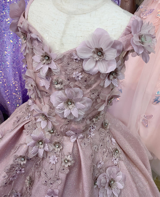 Close-up of a pink dress with floral embellishments on a mannequin.