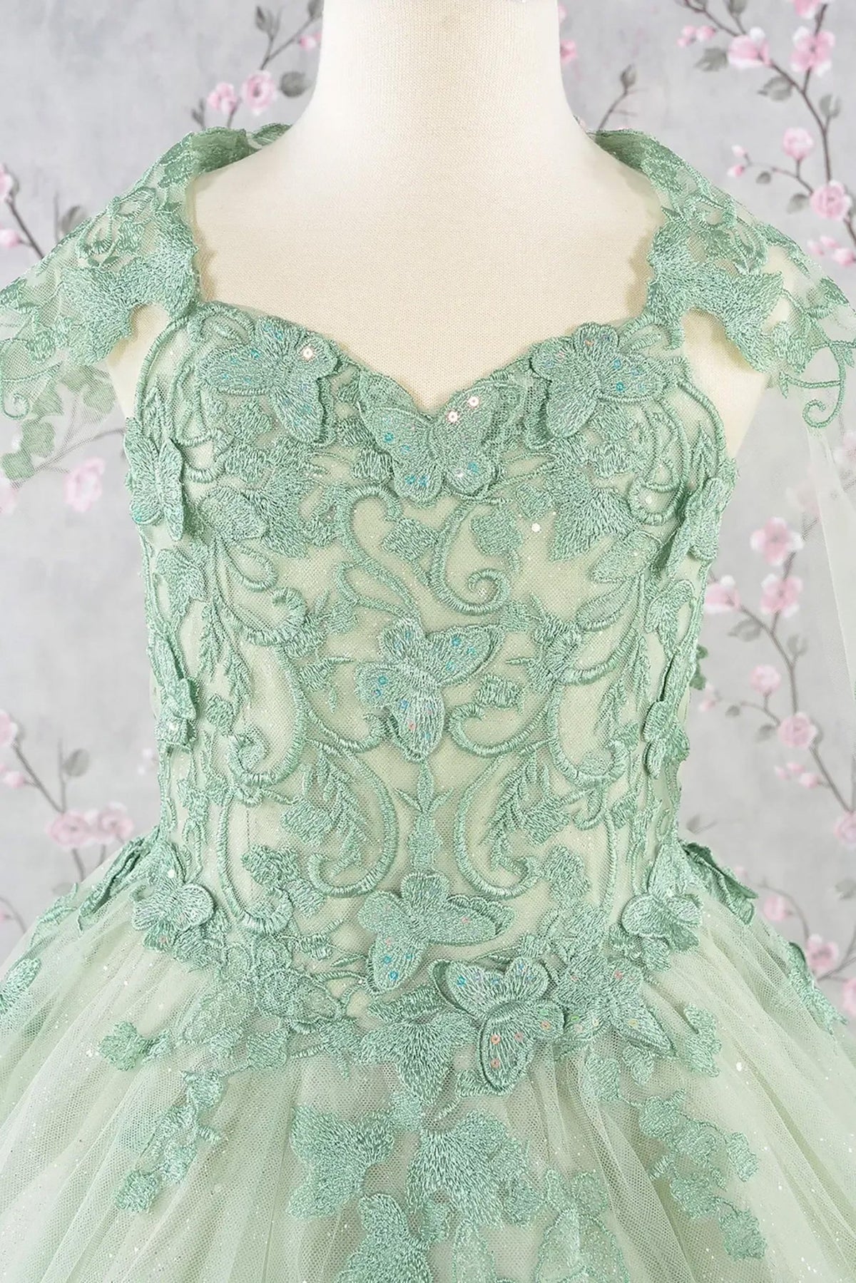 Close-up view reveals zoom Sage Green lace mini quince dress highlighting lace texture and embellishments.