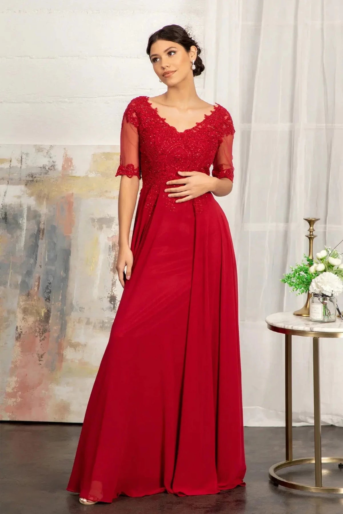 Bodice close-up highlights burgundy chiffon a-line mother of the bride dress with v-neckline.