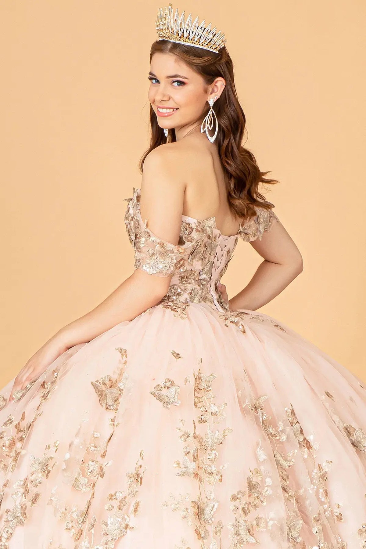 Layered skirt showcases the Rose Gold quinceañera ball gown with 3d butterfly appliqués.