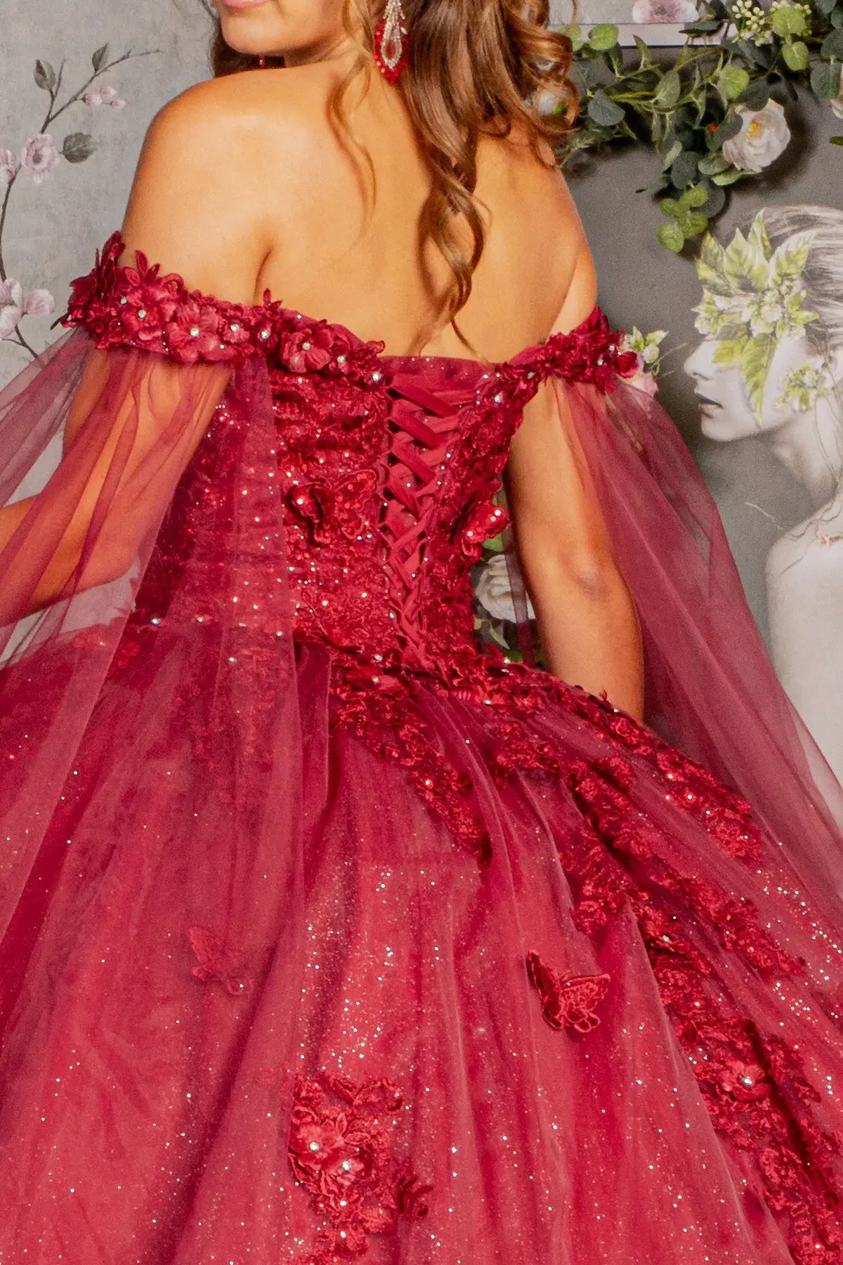 Layered skirt showcases the Burgundy quinceañera ball gown with detachable mesh drapes.