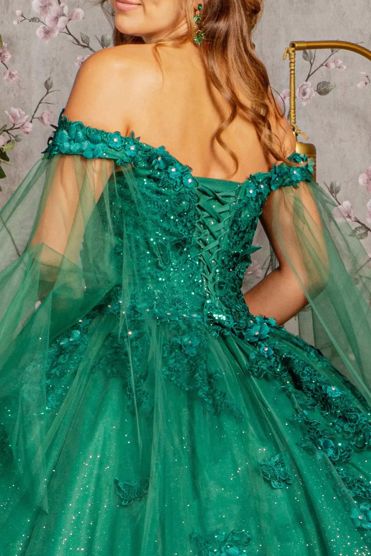 Layered skirt showcases the Hunter Green quinceañera ball gown with detachable mesh drapes.