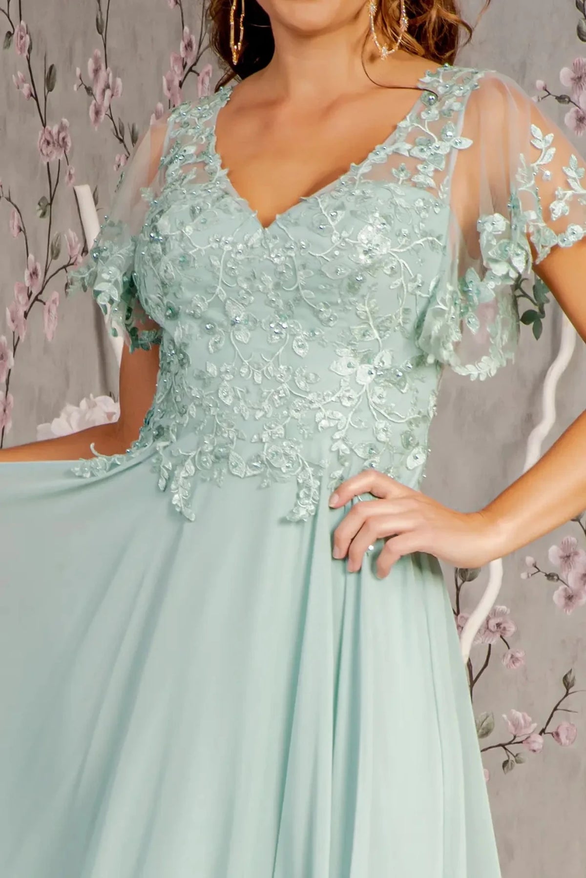 Close-up view reveals sage mother of the bride dress featuring sweetheart bodice with short sleeve and applique, beads, embroidery.
