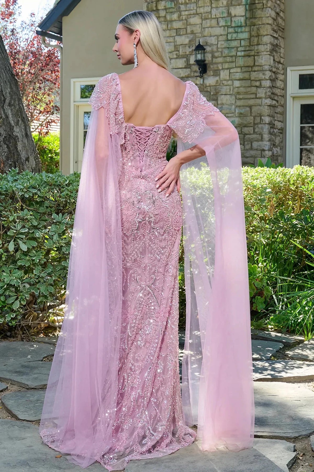 Rear view reveals dusty Rose fitted mother of the bride dress with corset back and cape sleeve.