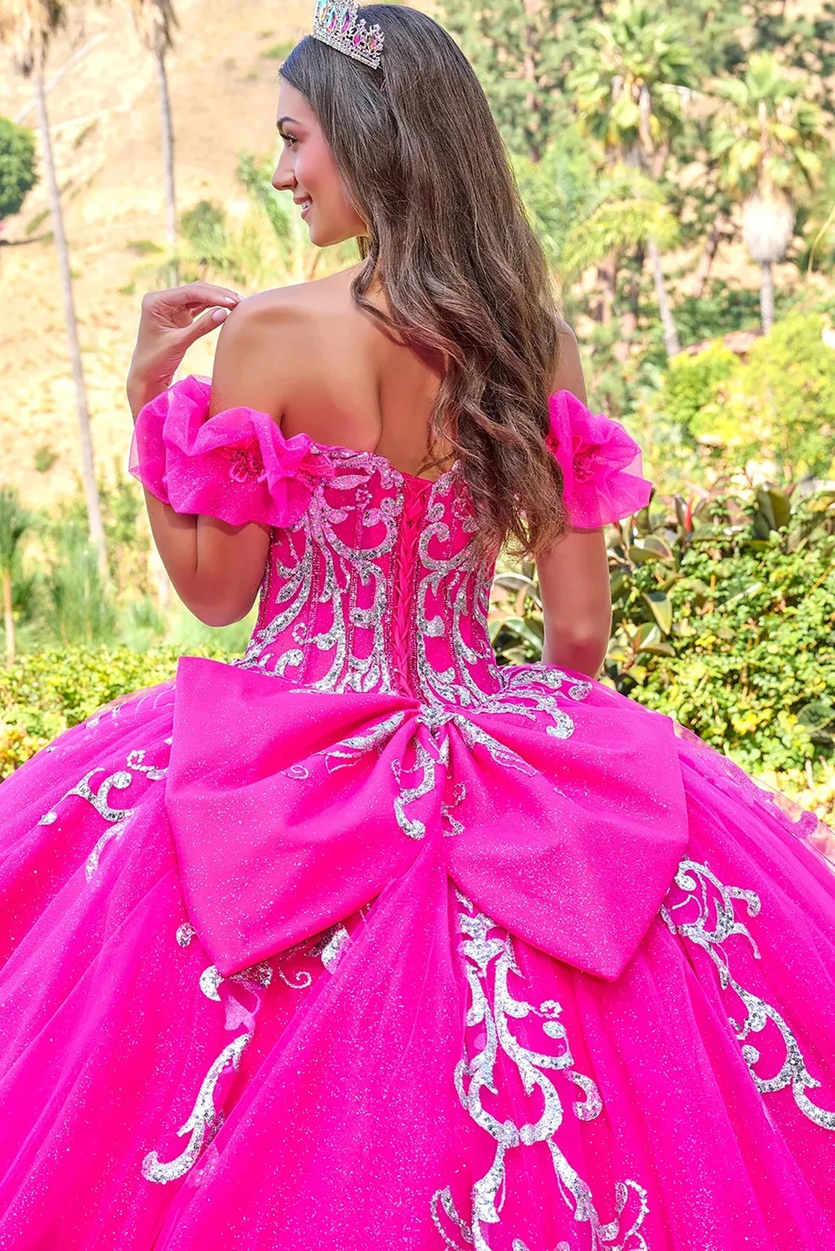 Back detail shows a fuchsia quinceañera dress with floral applique puff sleeves corset bodice ball gown.