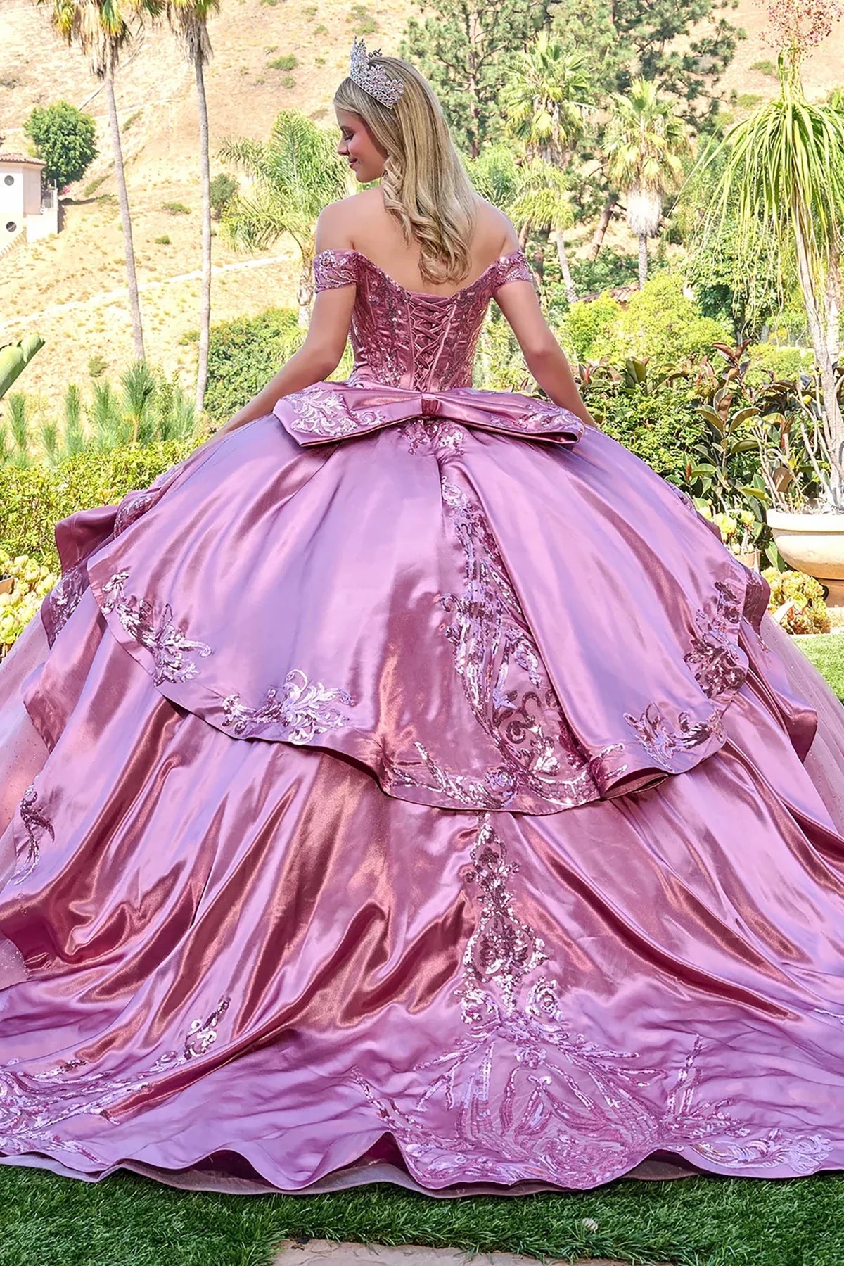 Rear view reveals dusty rose quinceañera dress with beaded embellishments tiara satin overskirt.