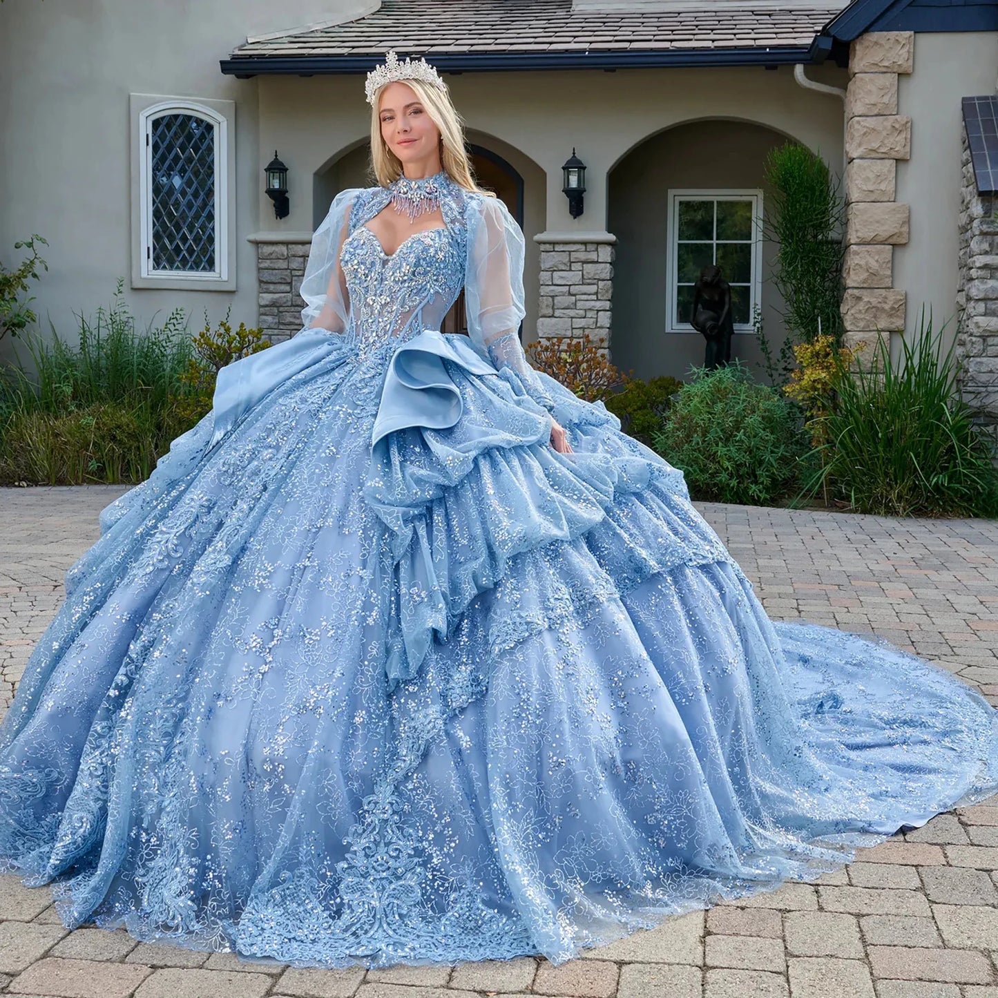 Front view of a woman wearing dusty blue quinceañera dress with beaded corset bodice satin ruffle overskirt