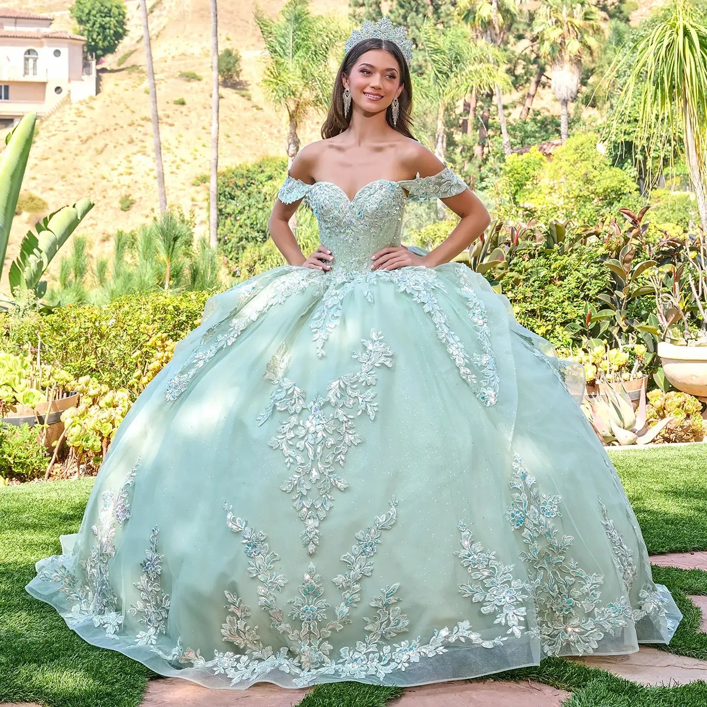 Front view of a woman wearing sage green quinceañera dress with floral embroidery sweetheart neckline tiered ruffle skirt
