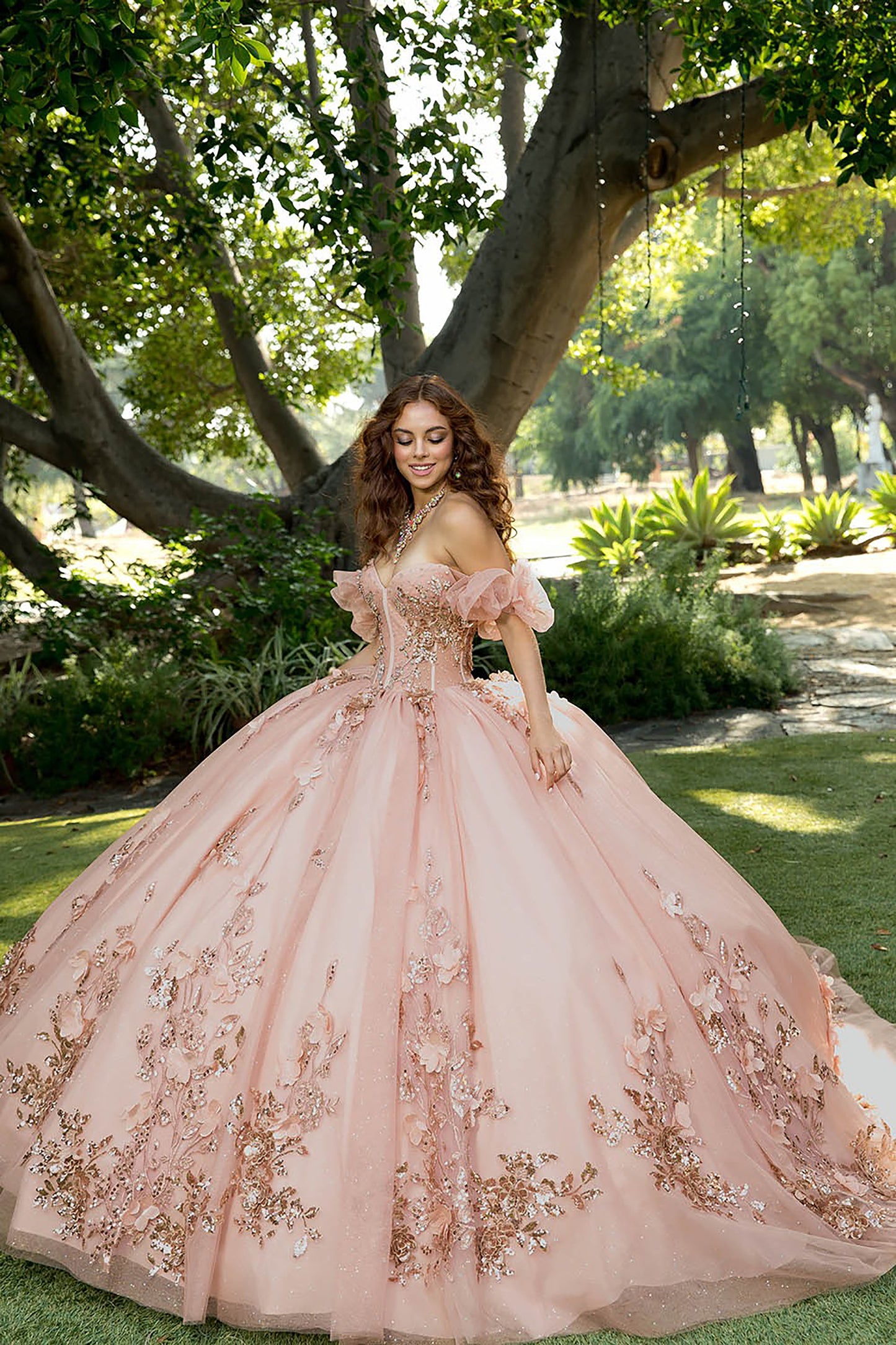 Woman in a pink floral dress standing in a garden