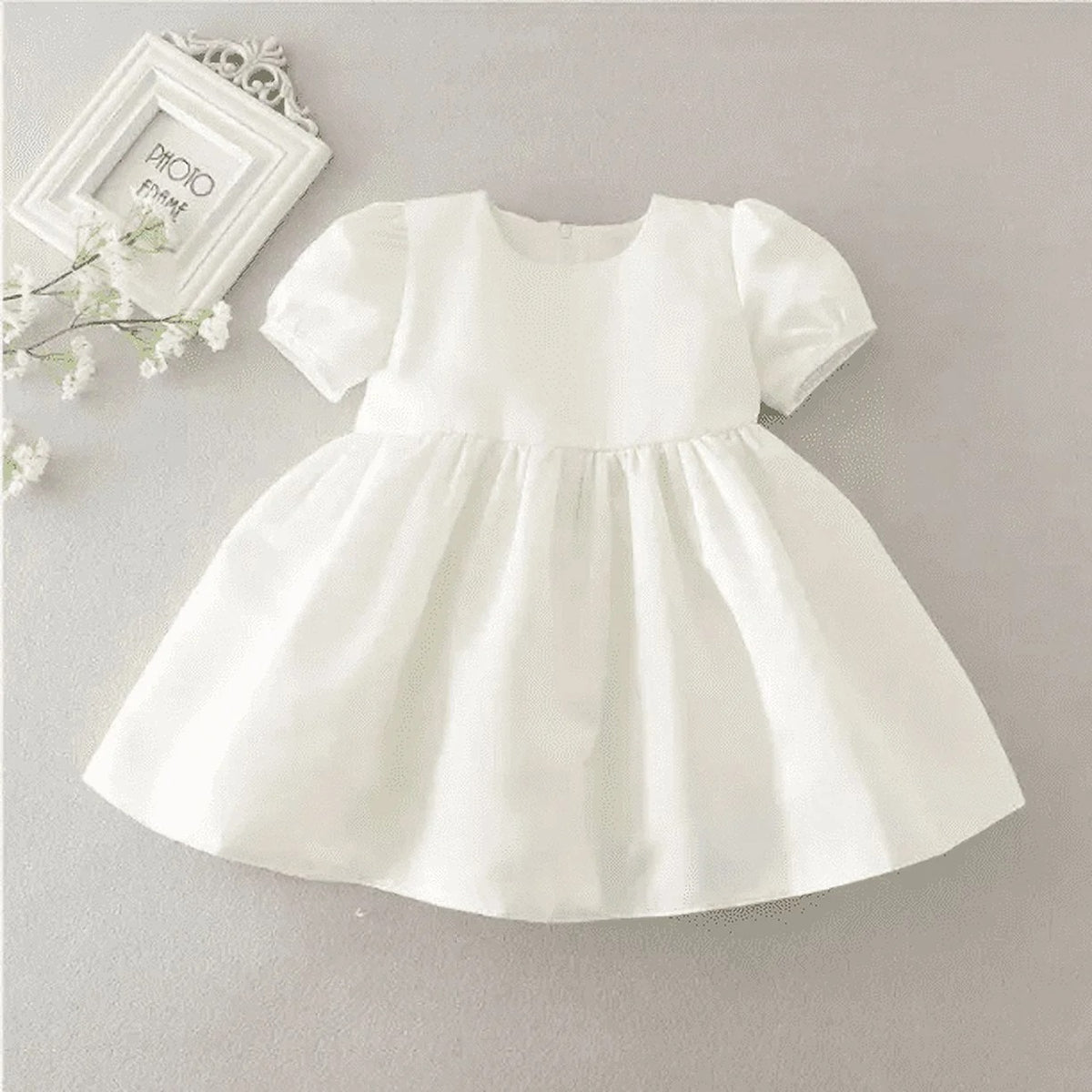Intricate features stand out across baby White Lace communion dress.
