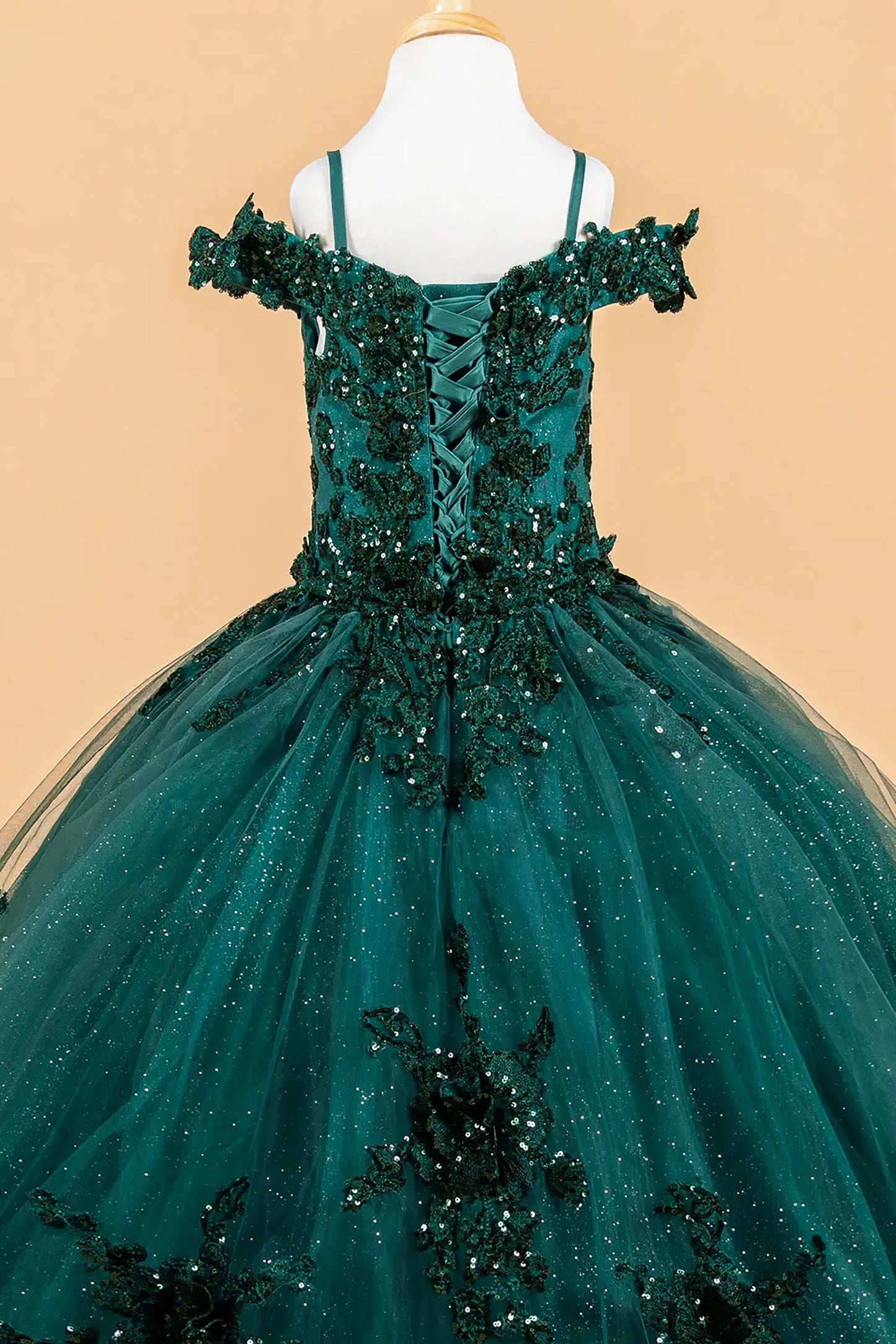 green evening gown with embellishments on a beige background