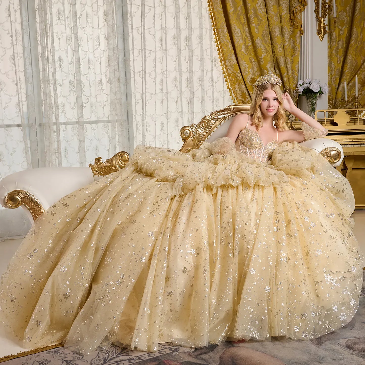 Woman in a luxurious gold gown sitting on an ornate chair in an elegant room.