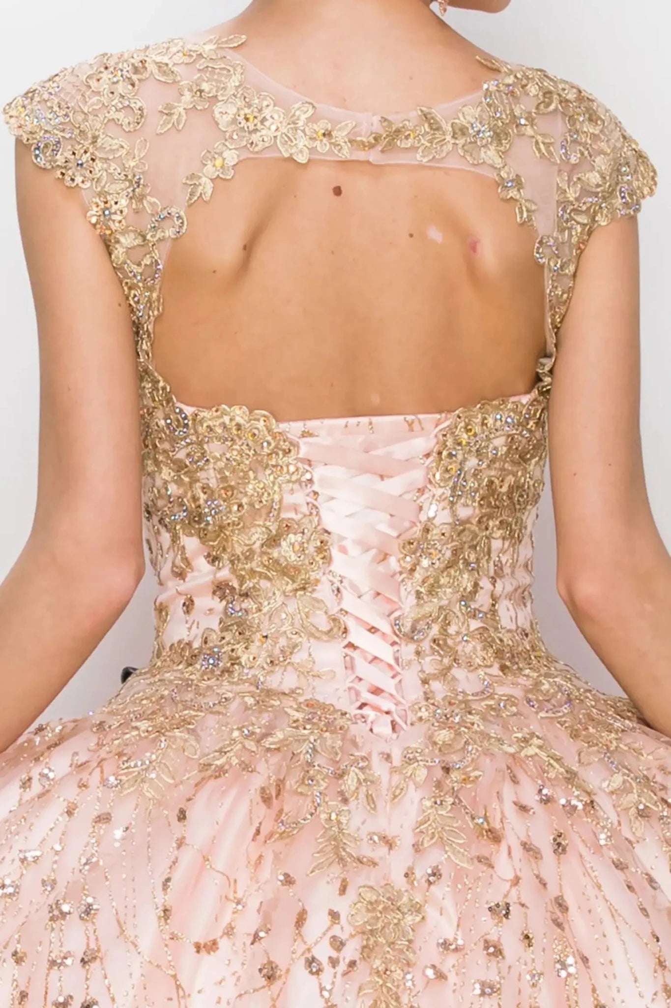 Close-up of a pink and gold embroidered dress with a plain background