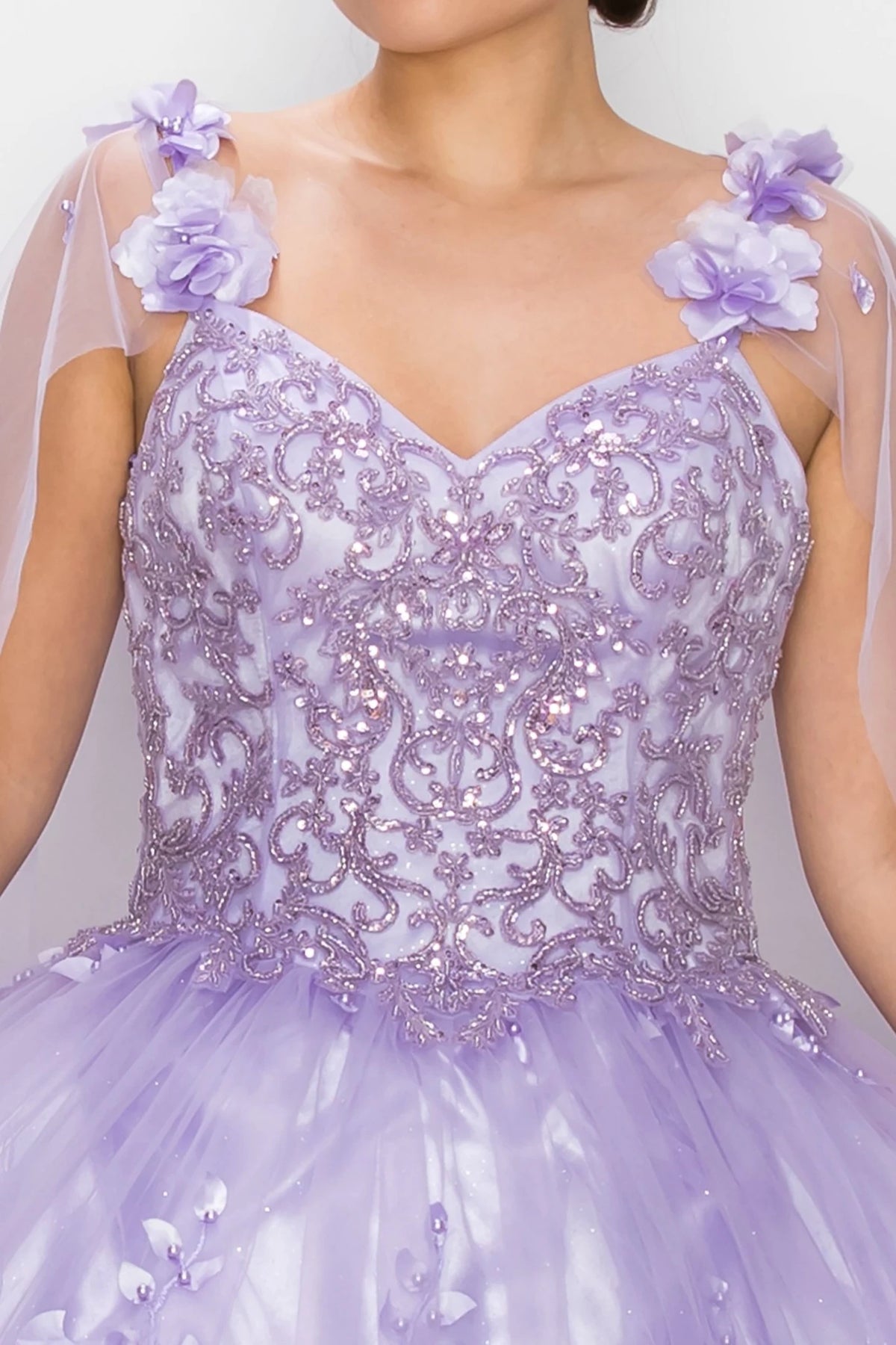Detailed view highlights Lilac quinceanera dress with floral shoulder appliques, pearl embellishments, and glitter tulle.