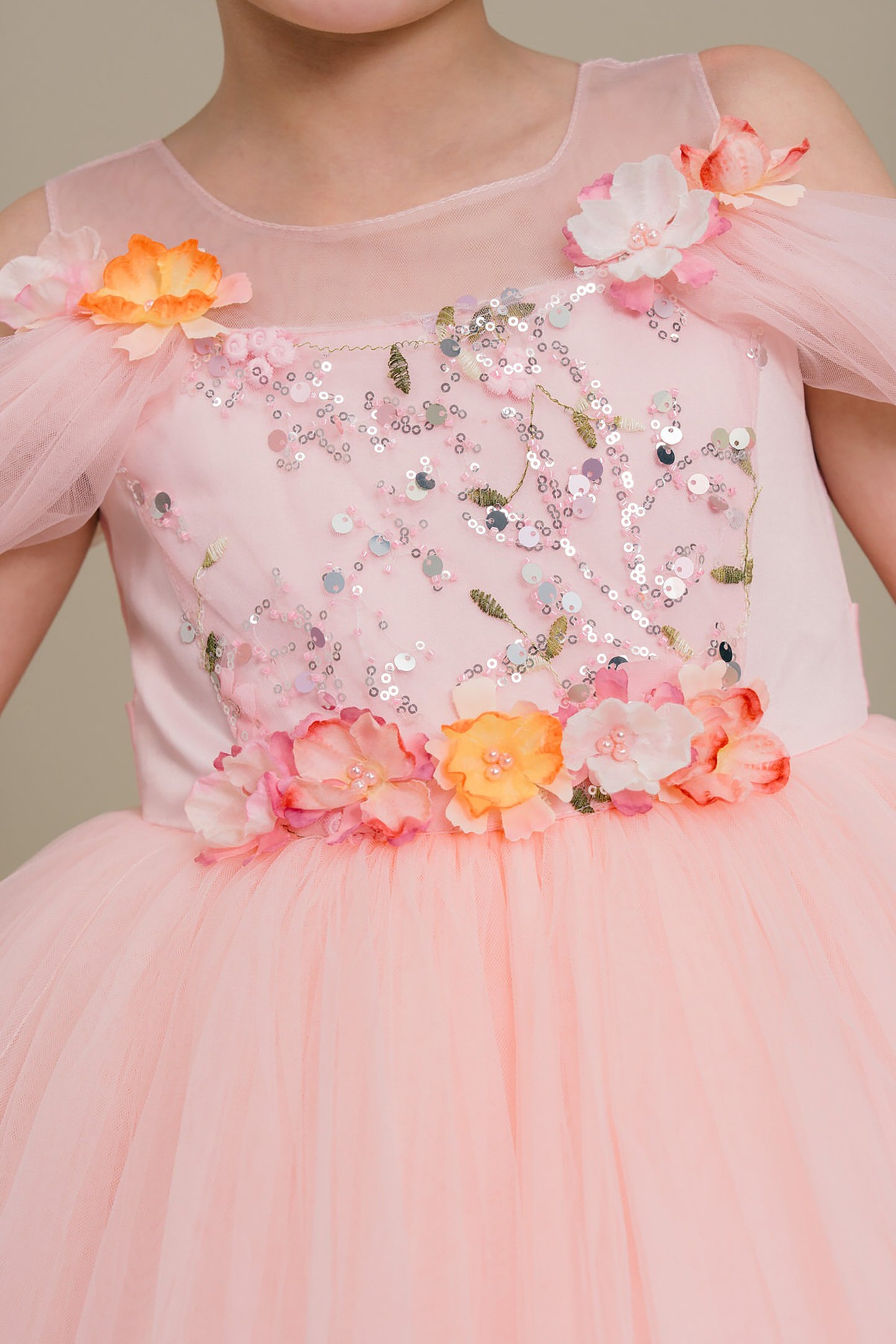 Pink dress with floral embellishments on a plain background
