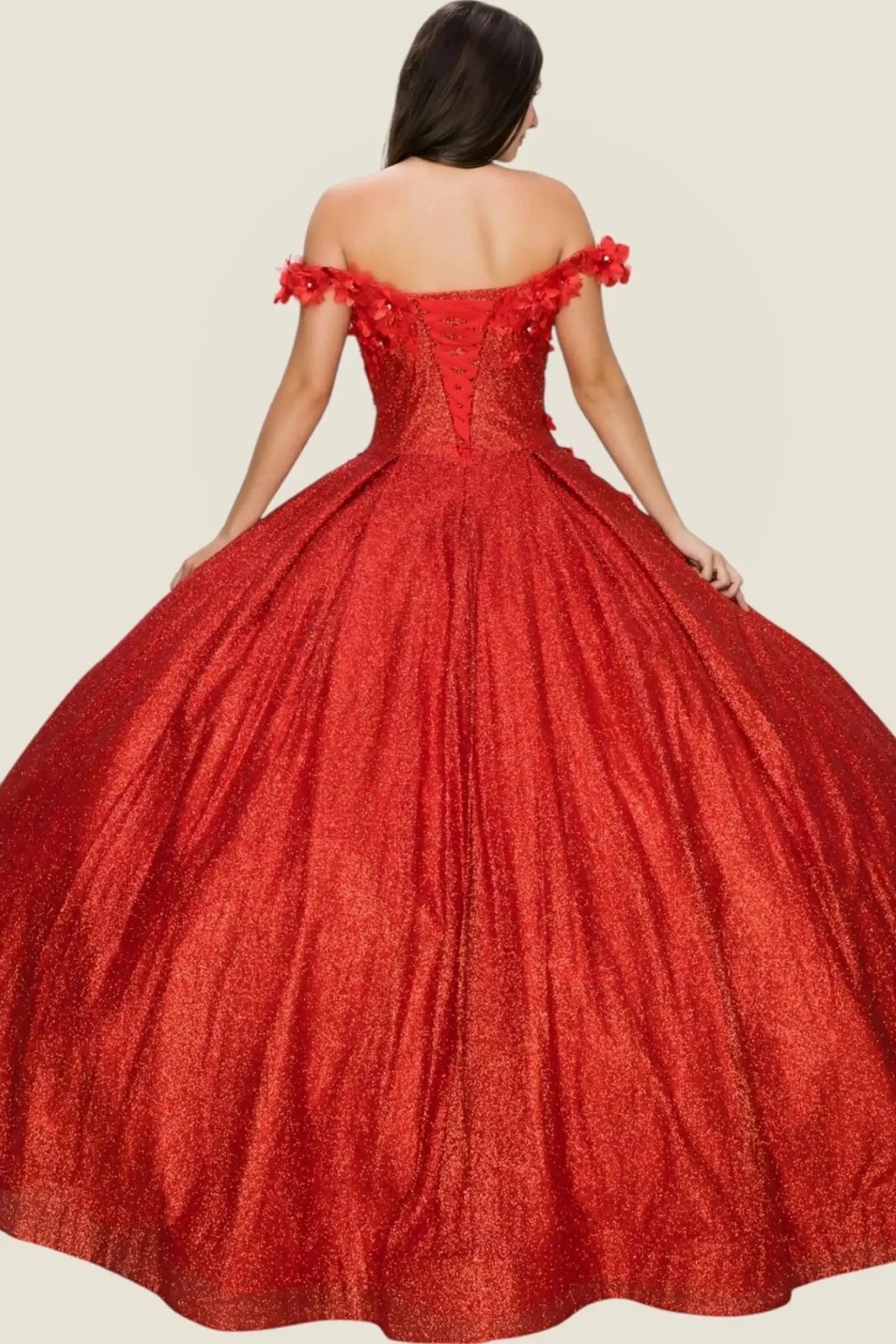 Rear view reveals red quinceanera dress with off-shoulder floral appliques, glitter details, and pleated beaded skirt.