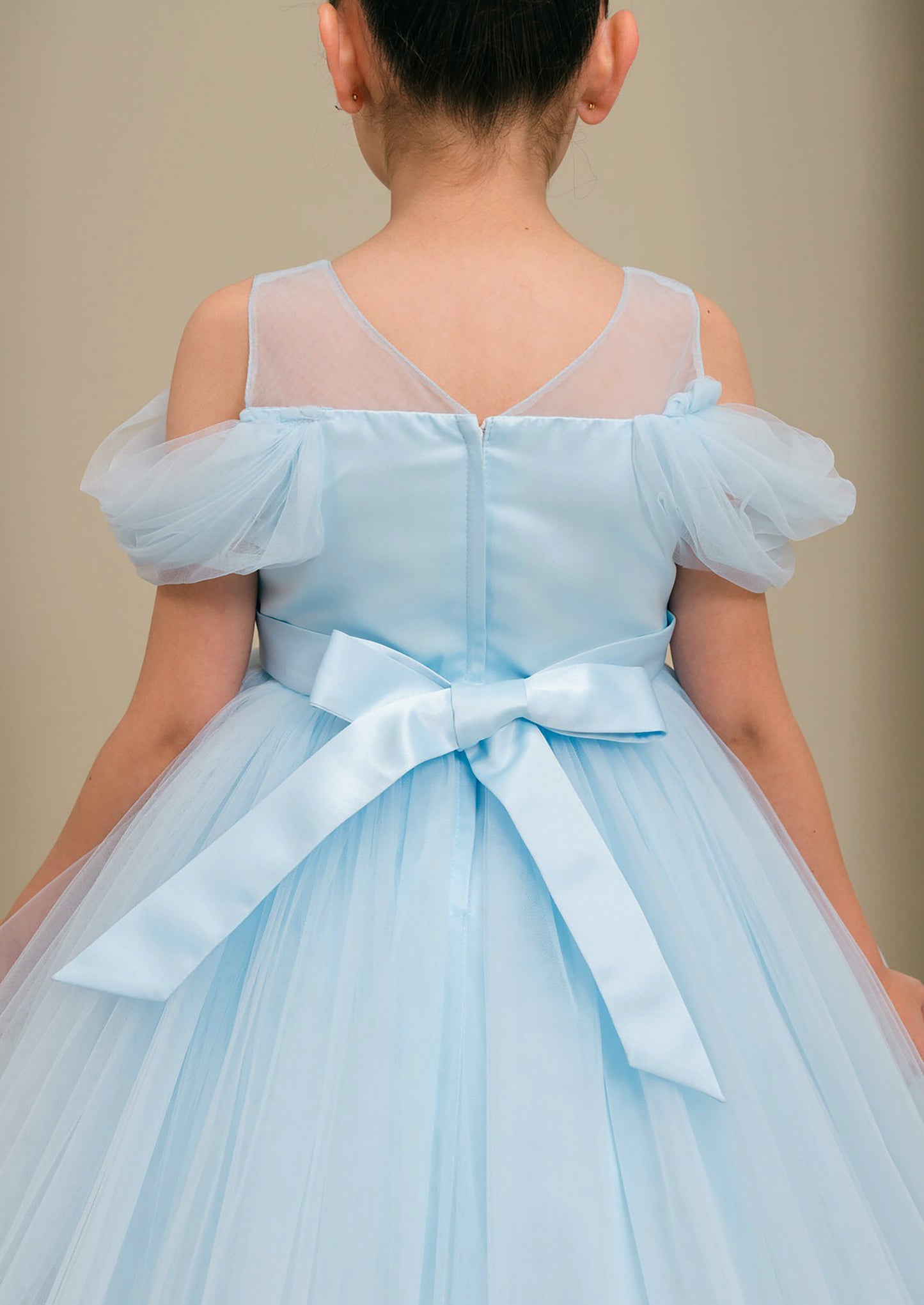 Light blue dress with a bow on a plain background