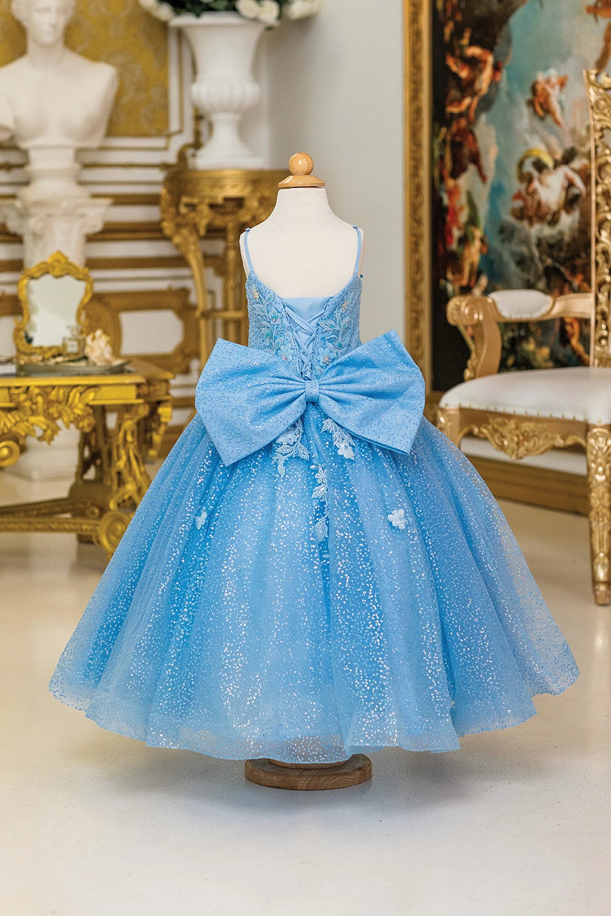 Turning to the back, the Bahama Blue mini quinceañera dress features oversized bow centered beneath the lace-up back.