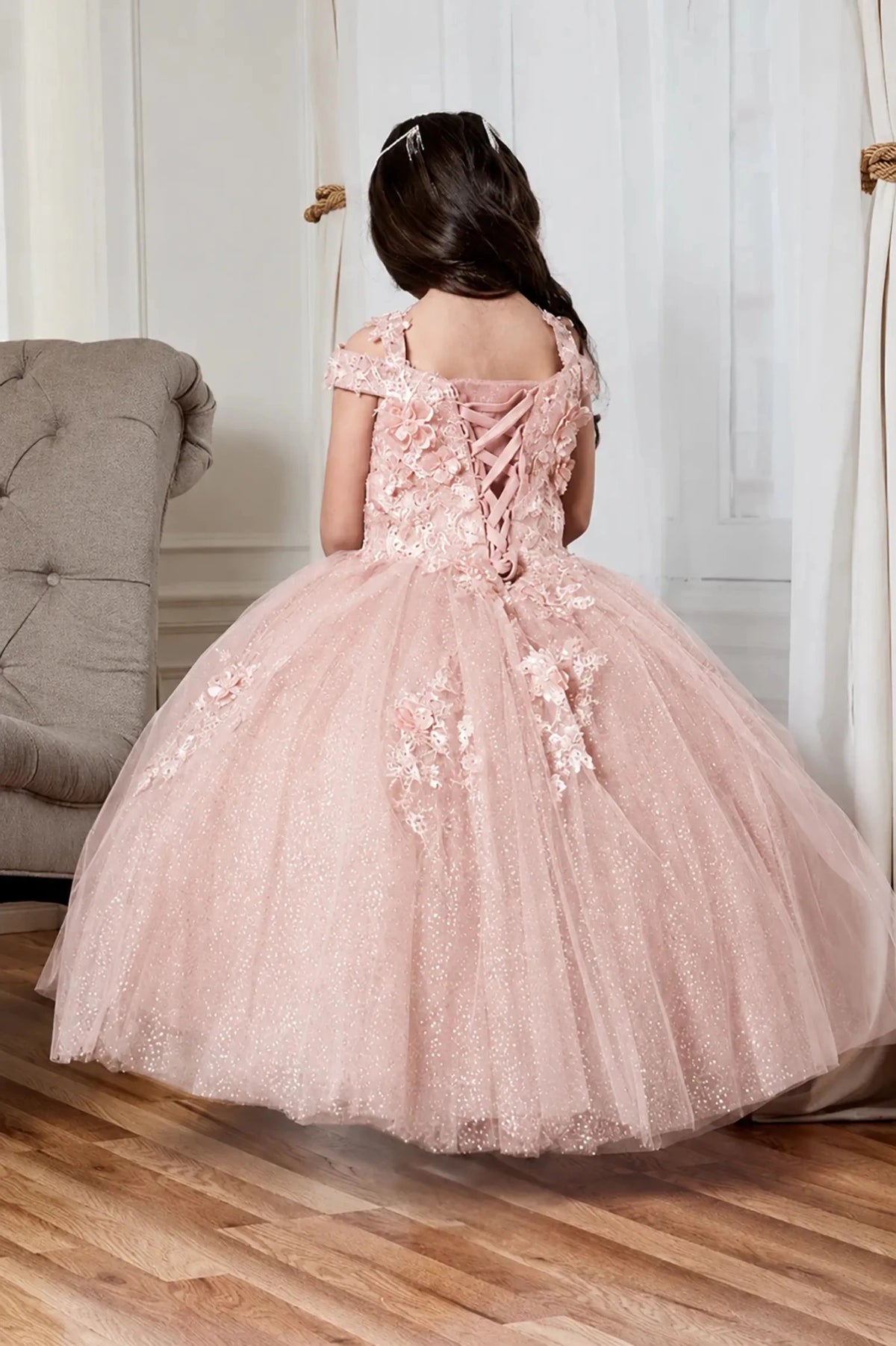 a voluminous light pink mini quince pageant mini quince dress with floral applique and lace-up back details,.