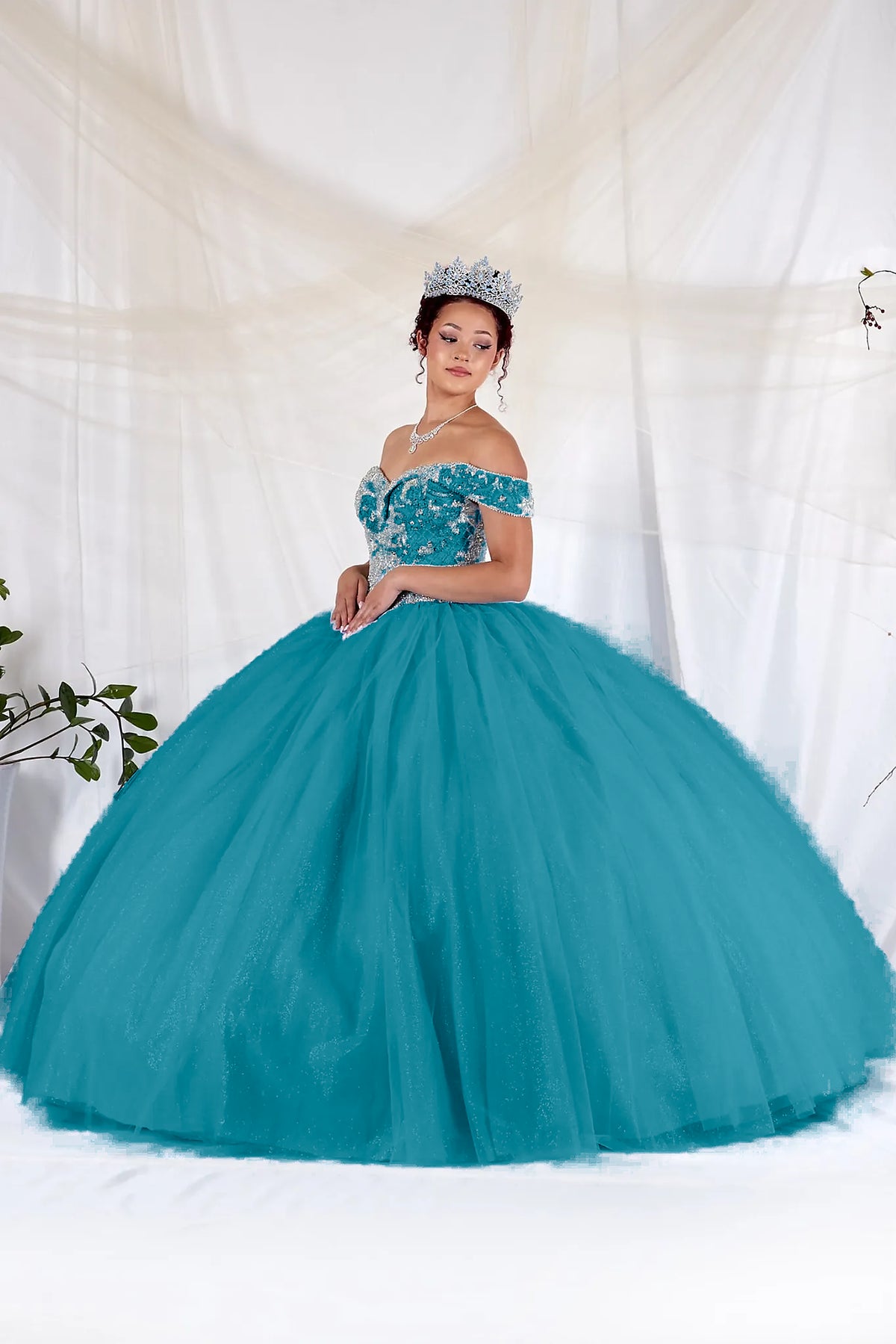 A voluminous tulle skirt balances the fitted embroidered bodice of this Jade/Gold quinceañera ball gown.