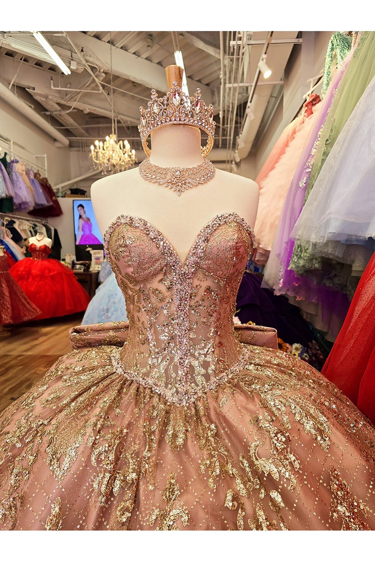 Zoomed front view of a champagne quinceañera ball gown with see-through corset bodice, sparkling sequins and gem embellishments