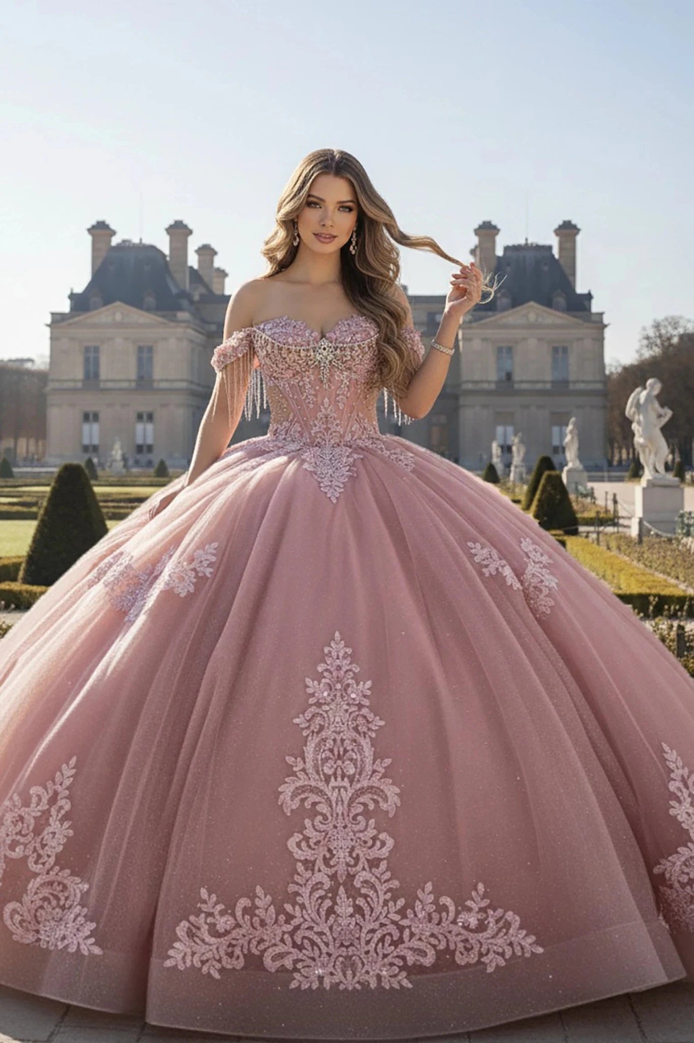 Woman in a rose ball gown with intricate embroidery standing in front of a classical building.