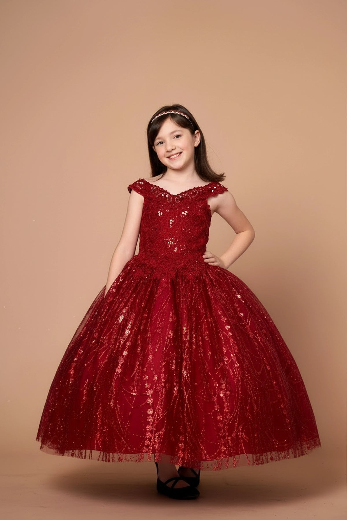 In full view, the Burgundy mini quince dress showcases off-the-shoulder bodice with allover sequins and glitter and matching cape over a full sparkling skirt.