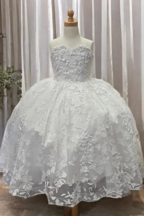 Front-facing view of white mini quince dress with 3D flower appliqué bodice, butterfly embellishments, glitter tulle detailing, and sweetheart neckline.