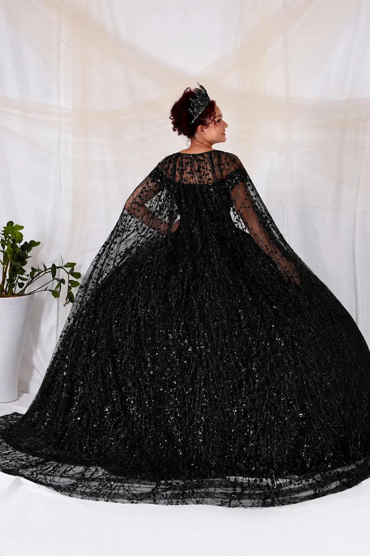 Person wearing a black lace quinceanera ball gown with a cape