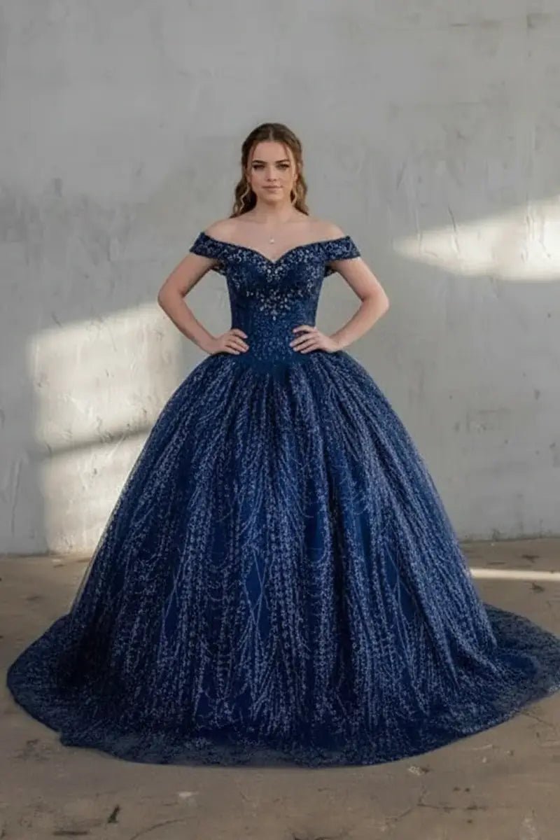 Front-Facing of a woman wearing Navy blue ball gown with off-shoulder neckline glittering sequins and flowing skirt paired with cape