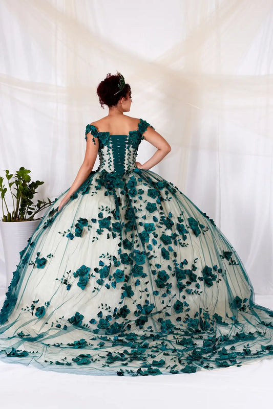 Back-Facing of a woman wearing Emerald formal gown featuring long trailing tail layered skirt and structured back design