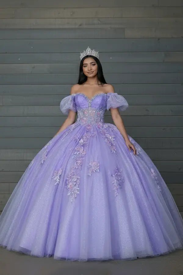 Front-Facing of a woman wearing Lilac gown featuring lace-up back flowing glitter tulle skirt and detachable cape detail