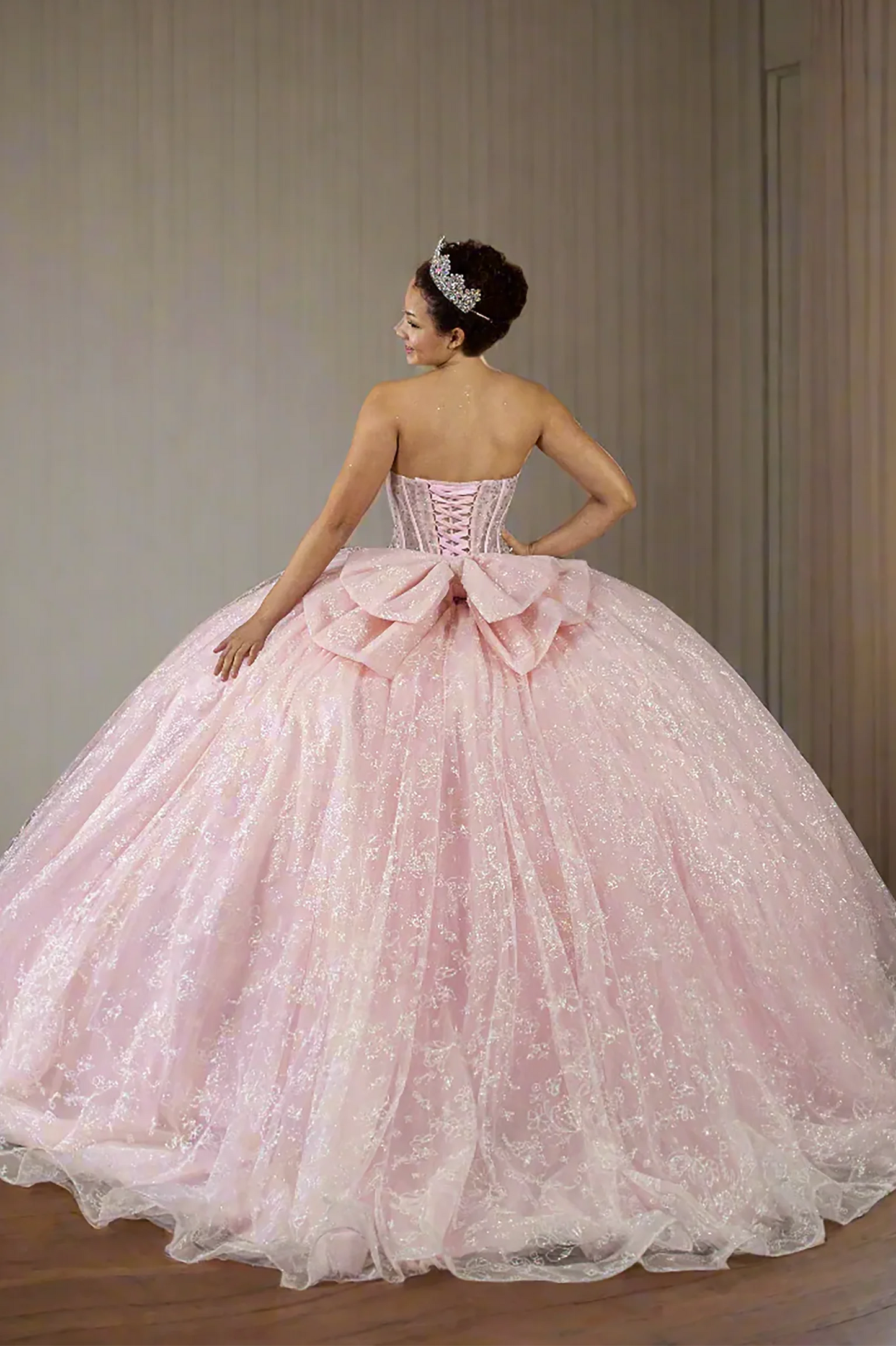 Back-Facing of a woman wearing Bubble pink formal gown featuring fitted bodice full skirt and soft flowing silhouette