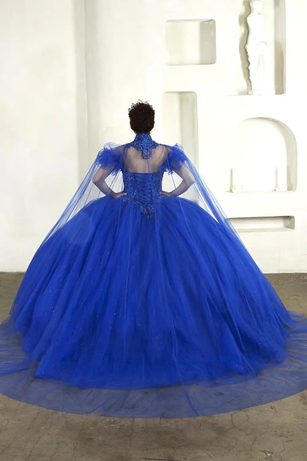 Royal blue quinceañera ball gown with removable ruffle sleeves, beaded bodice, glitter tulle and detachable cape