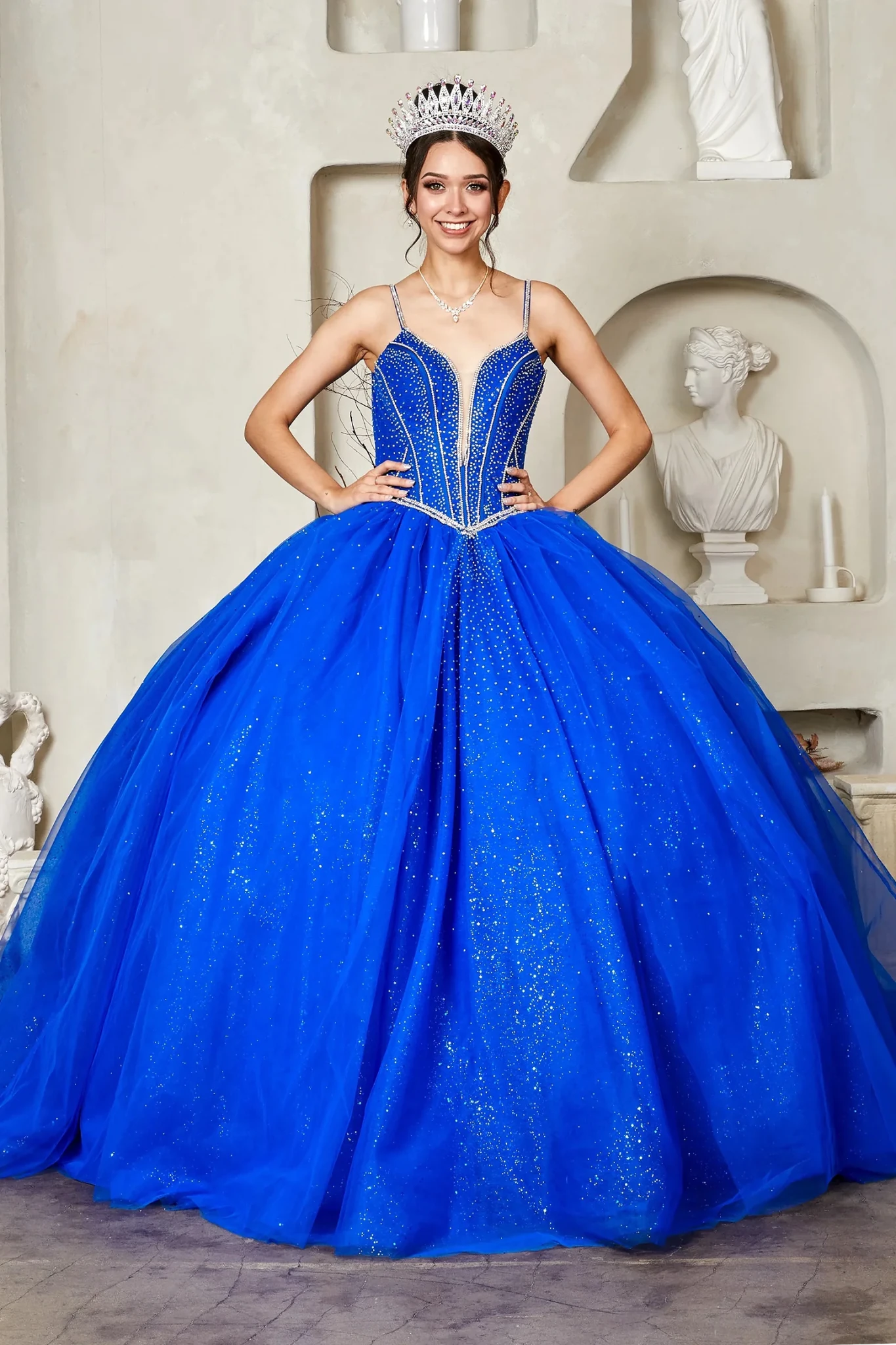 Royal blue quinceañera ball gown with crystal beaded corset, V‑neckline, spaghetti straps and glitter tulle skirt