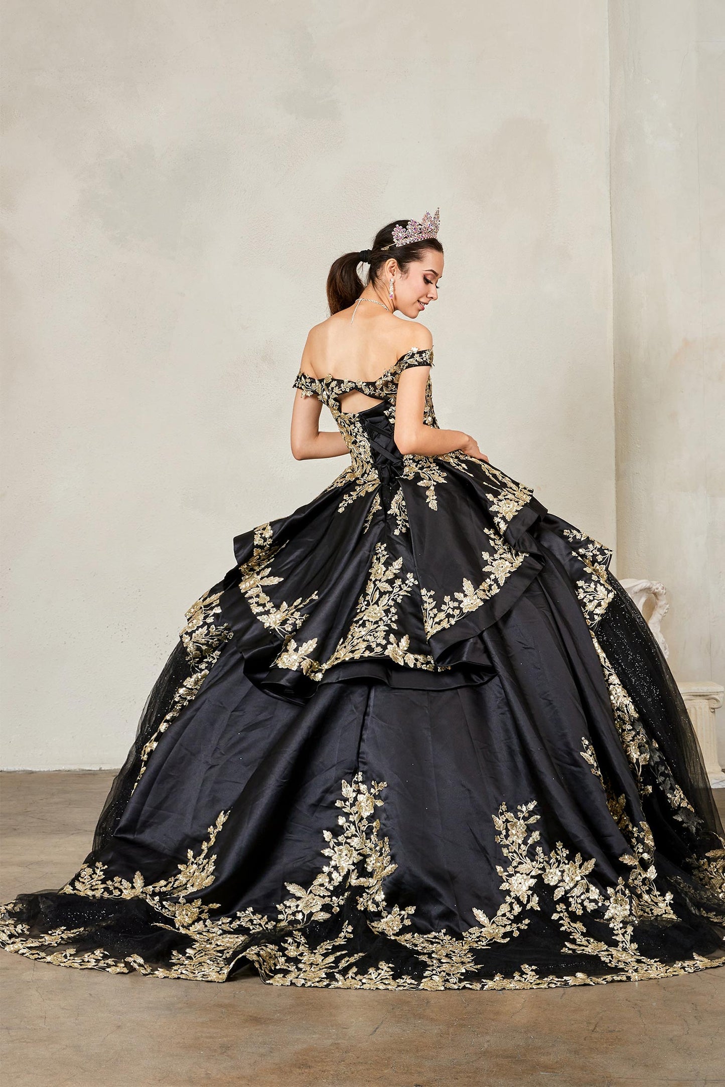 Navy quinceañera ball gown with beaded gold embroidery, glitter layered skirt and satin ruffle train