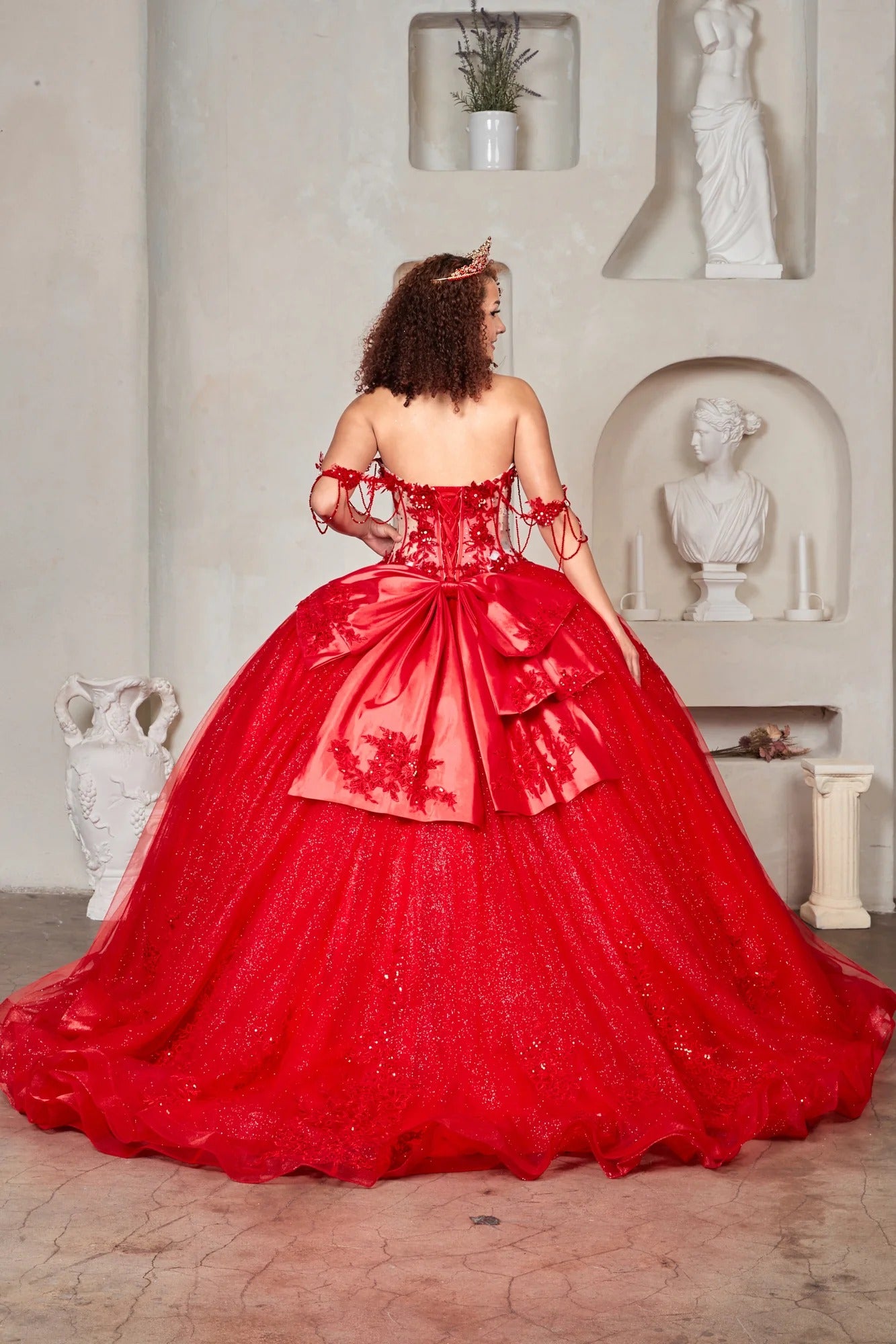 red ball gown with a structured corset-style bodice and large bow detail