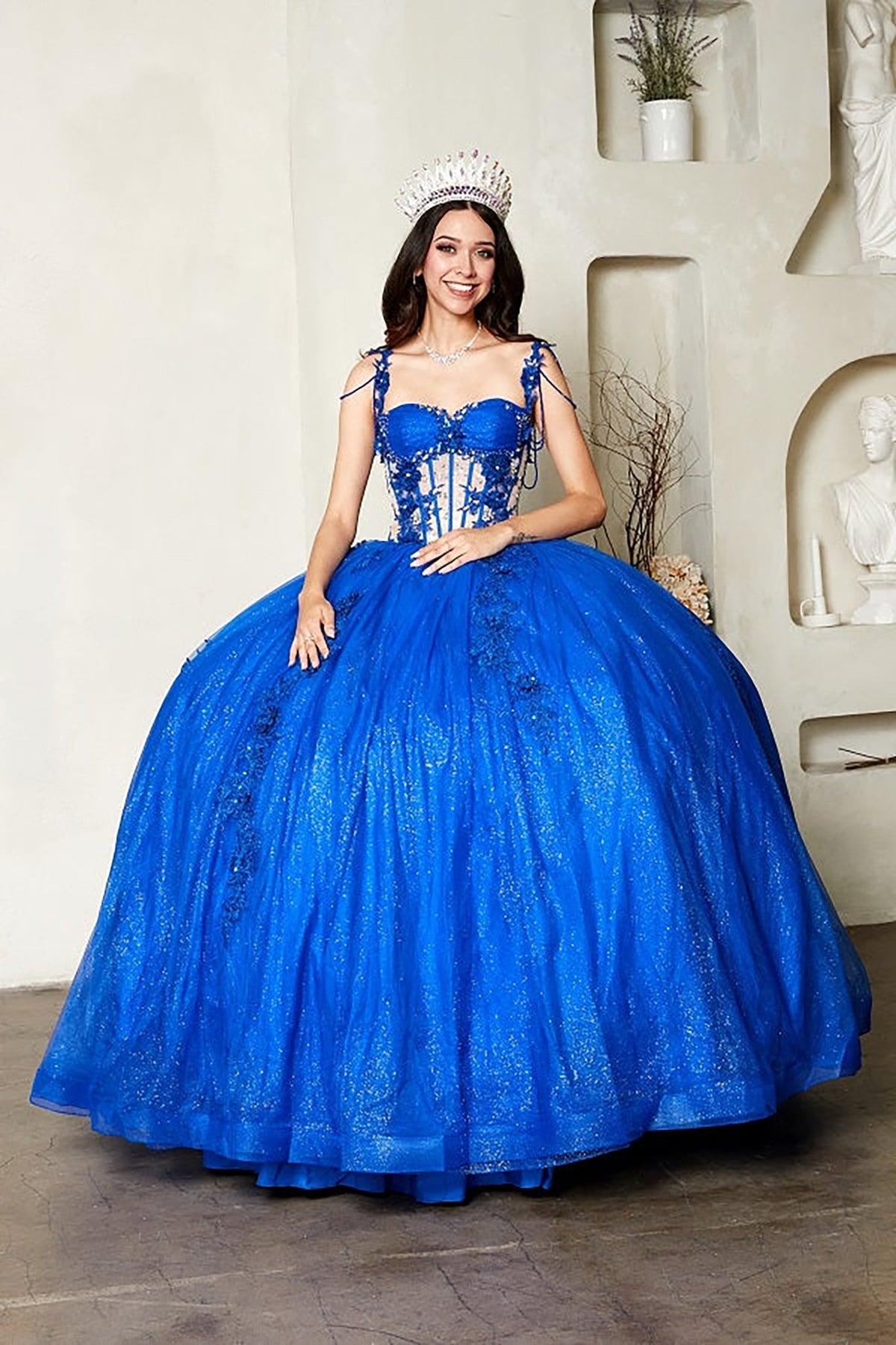 Intricate features stand out across royal blue quinceañera ball gown with sheer corset bodice, 3D floral embroidery, detachable bow.