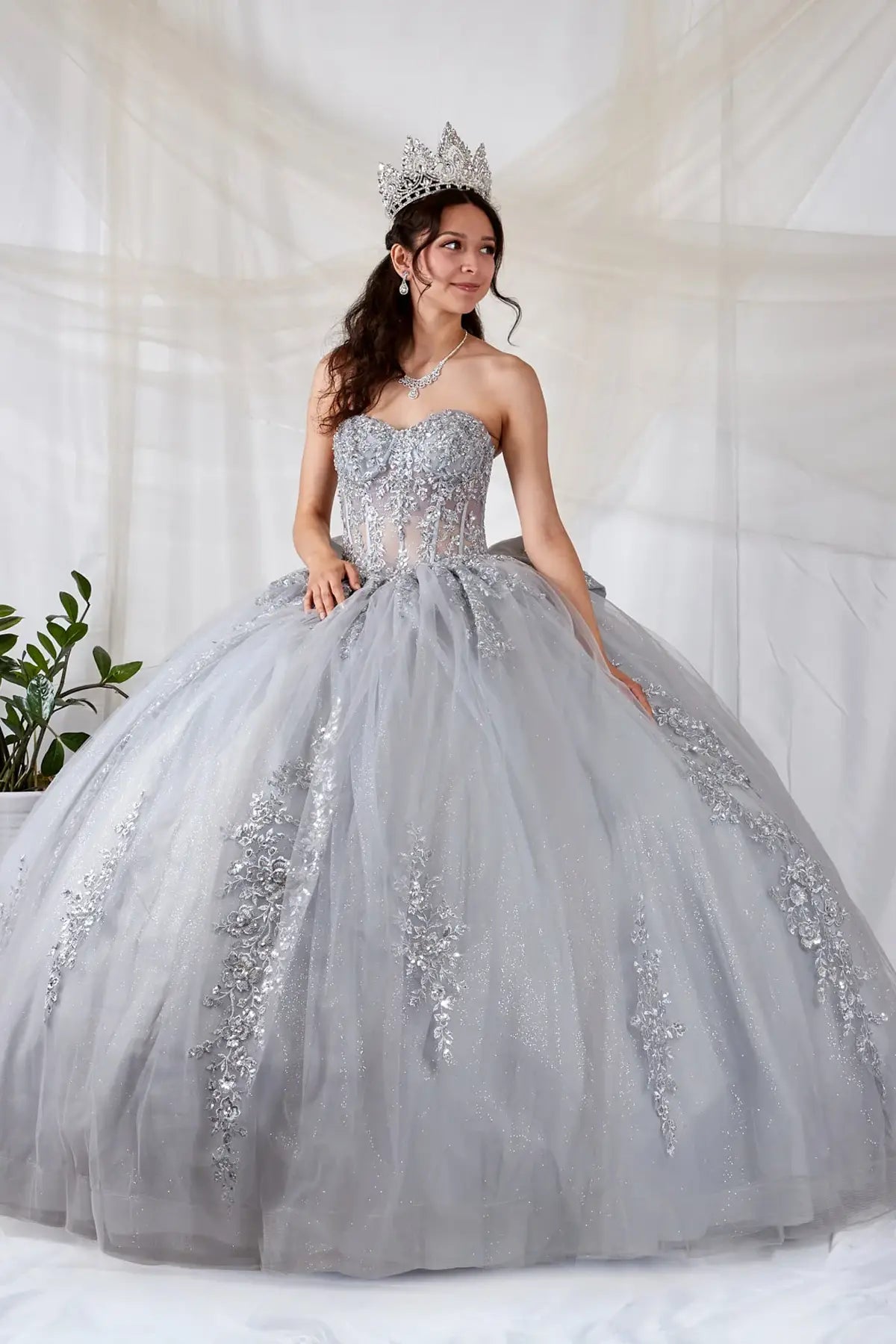 Silver quinceañera ball gown with sheer sweetheart bodice, floral embroidery and glitter tulle skirt