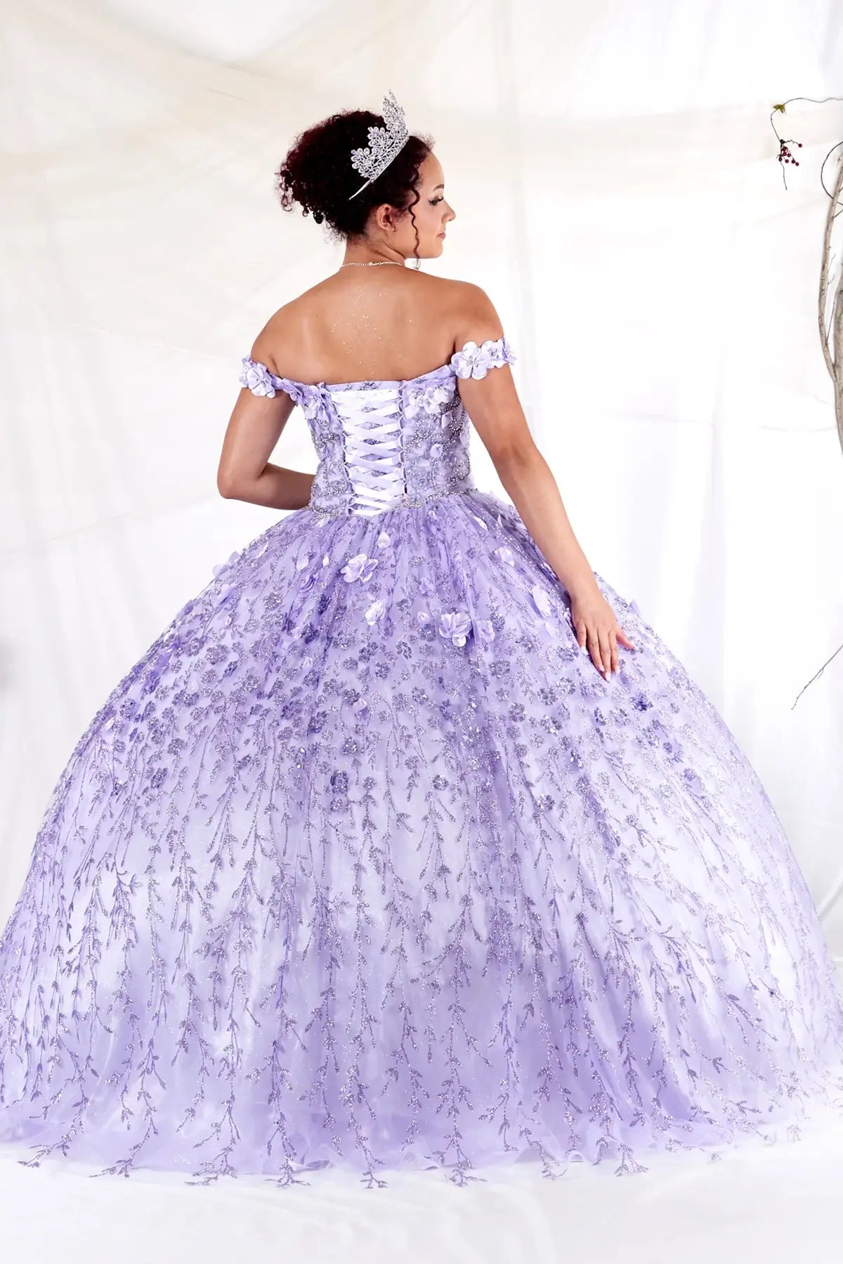 Back-Facing of a woman wearing Lilac formal gown featuring structured back layered skirt and flowing silhouette