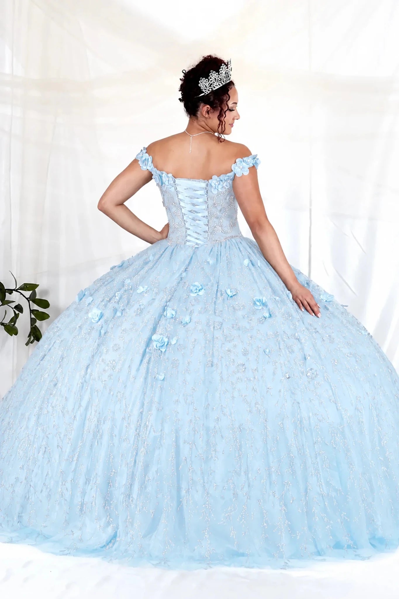 Bahama blue quinceañera ball gown with off‑shoulder neckline, delicate floral appliques and flowing skirt